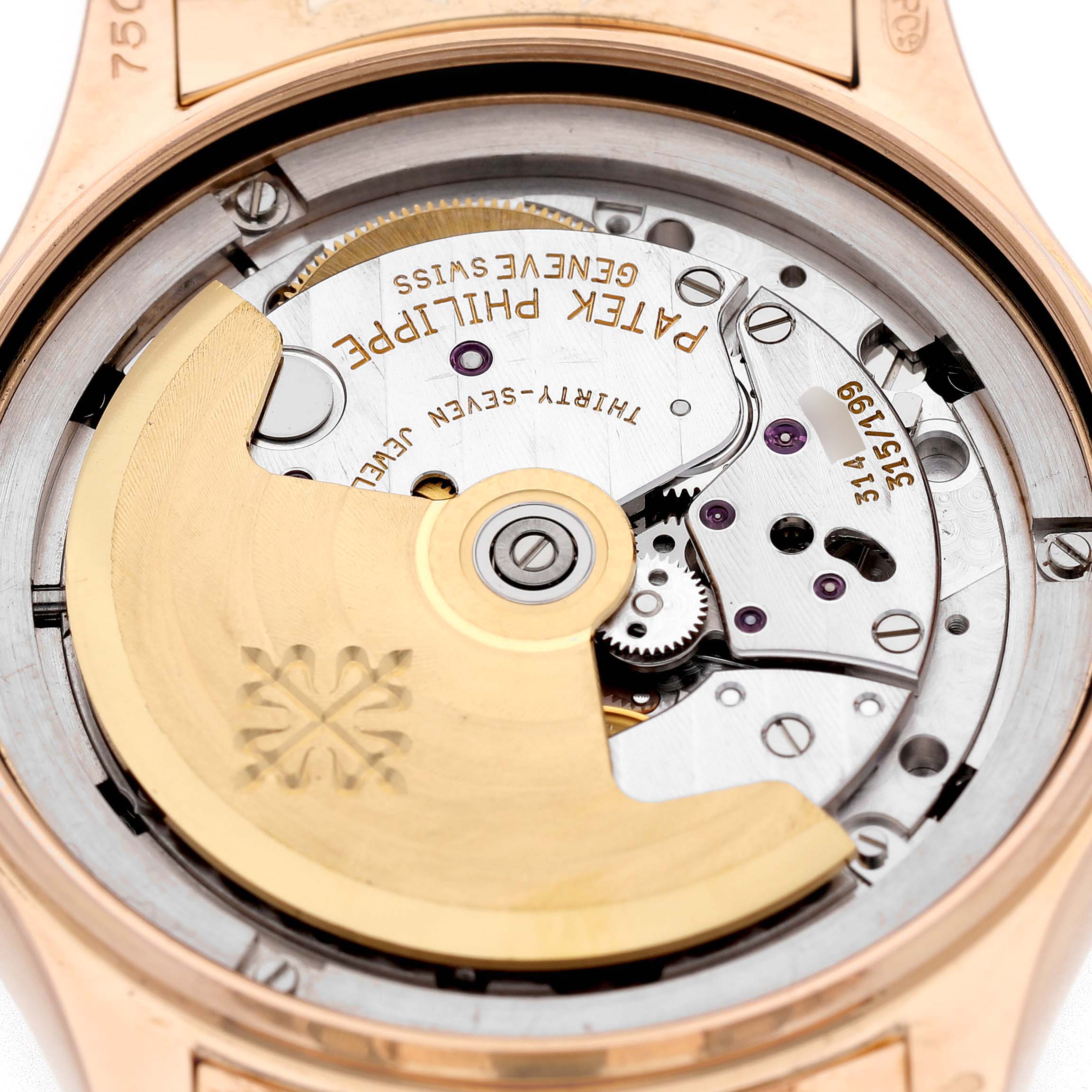 The image shows the movement of a Patek Philippe Complications 5036 Men's Rose Gold White Dial watch, highlighting the rotor and intricate internal mechanisms.
