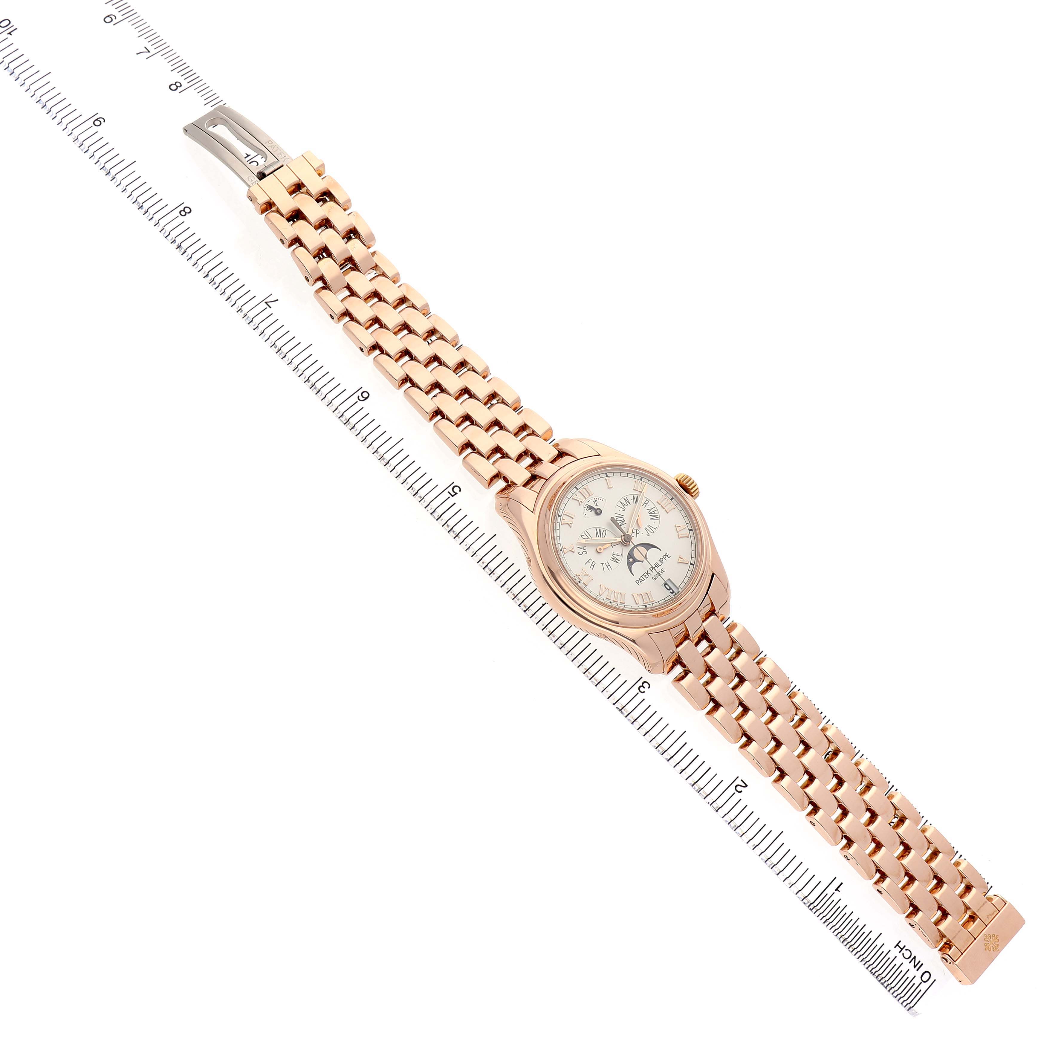 The Patek Philippe Complications 5036 Men's Rose Gold White Dial watch is shown from a top view, displaying the dial, bracelet, and clasp alongside a measuring scale.