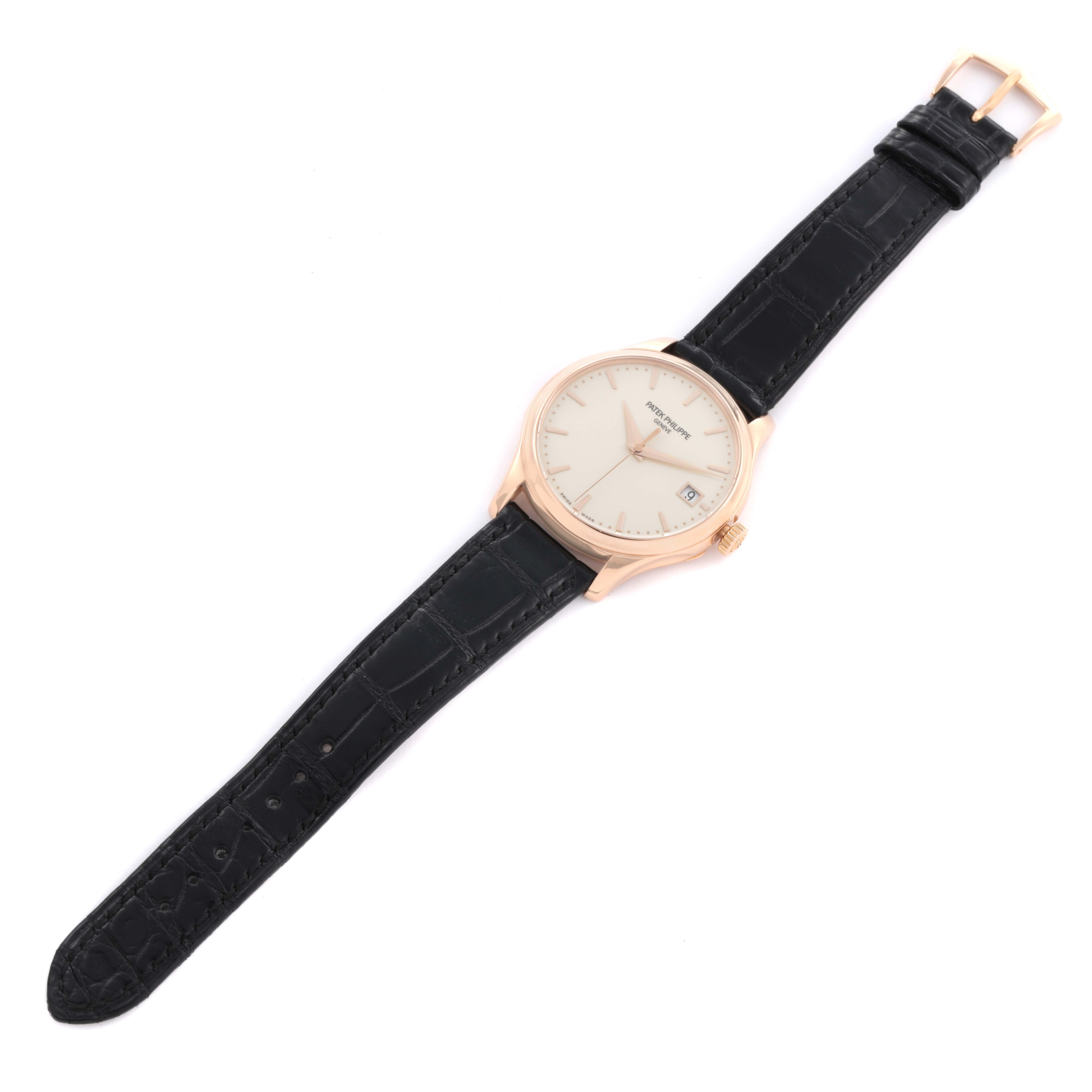 The Patek Philippe Calatrava 5227R Men's Rose Gold Beige Dial watch is shown from a top-down angle, displaying the dial, case, crown, and black leather strap.
