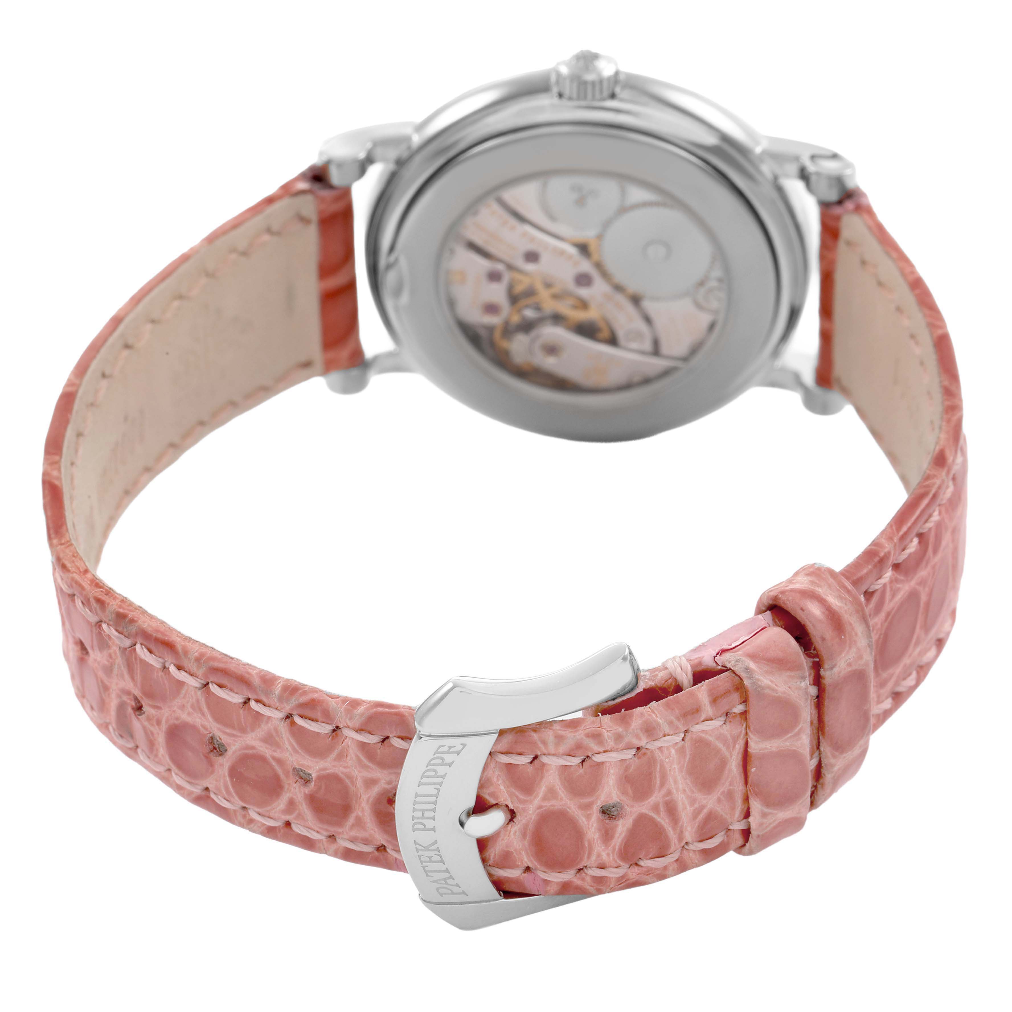 The image shows the back of a Patek Philippe Calatrava 4959G Women's White Gold Silver Dial watch with a visible movement and pink leather strap.