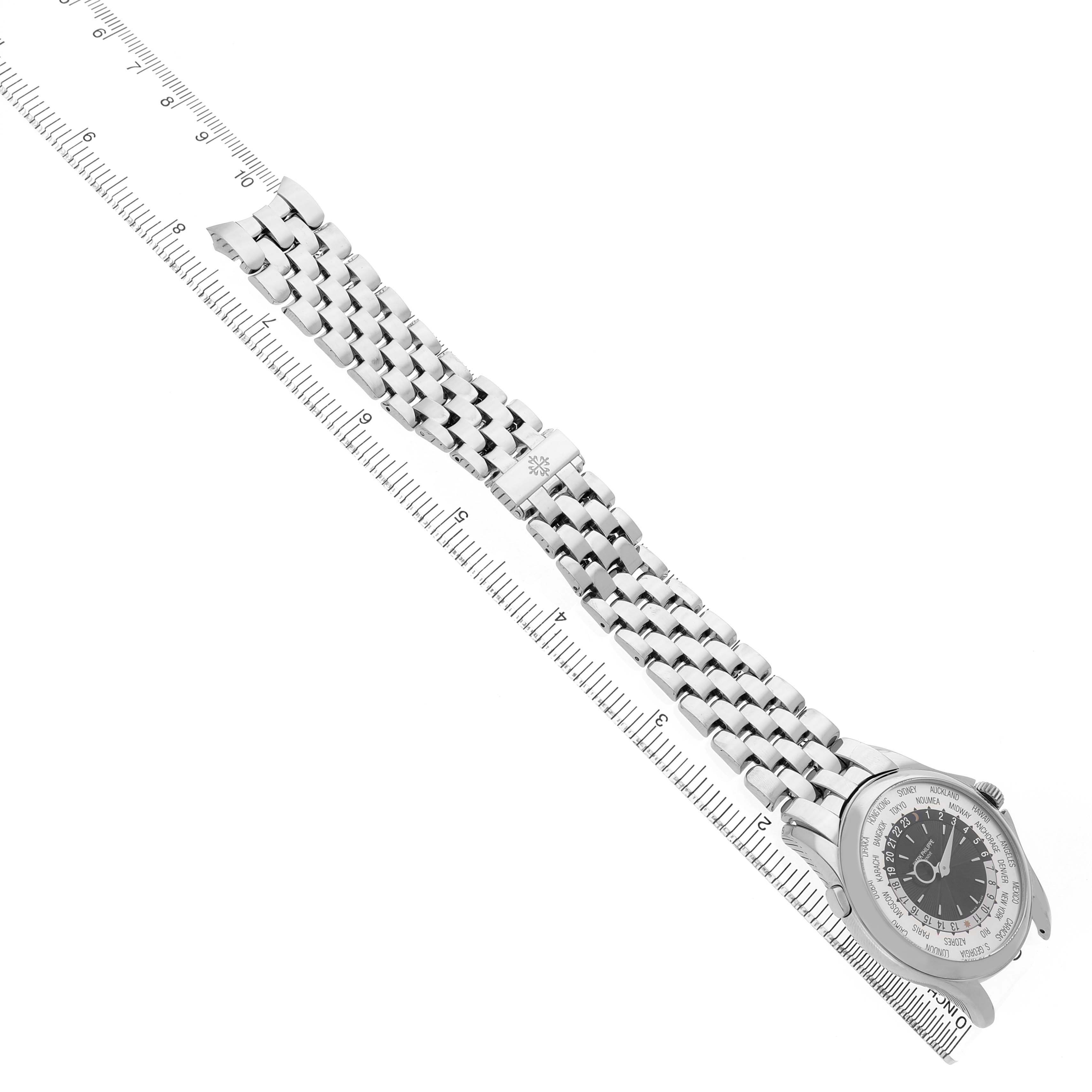 The image shows a Patek Philippe Complications 5130G Men's White Gold Silver Dial watch angled diagonally, displaying the face and metal bracelet alongside a ruler.