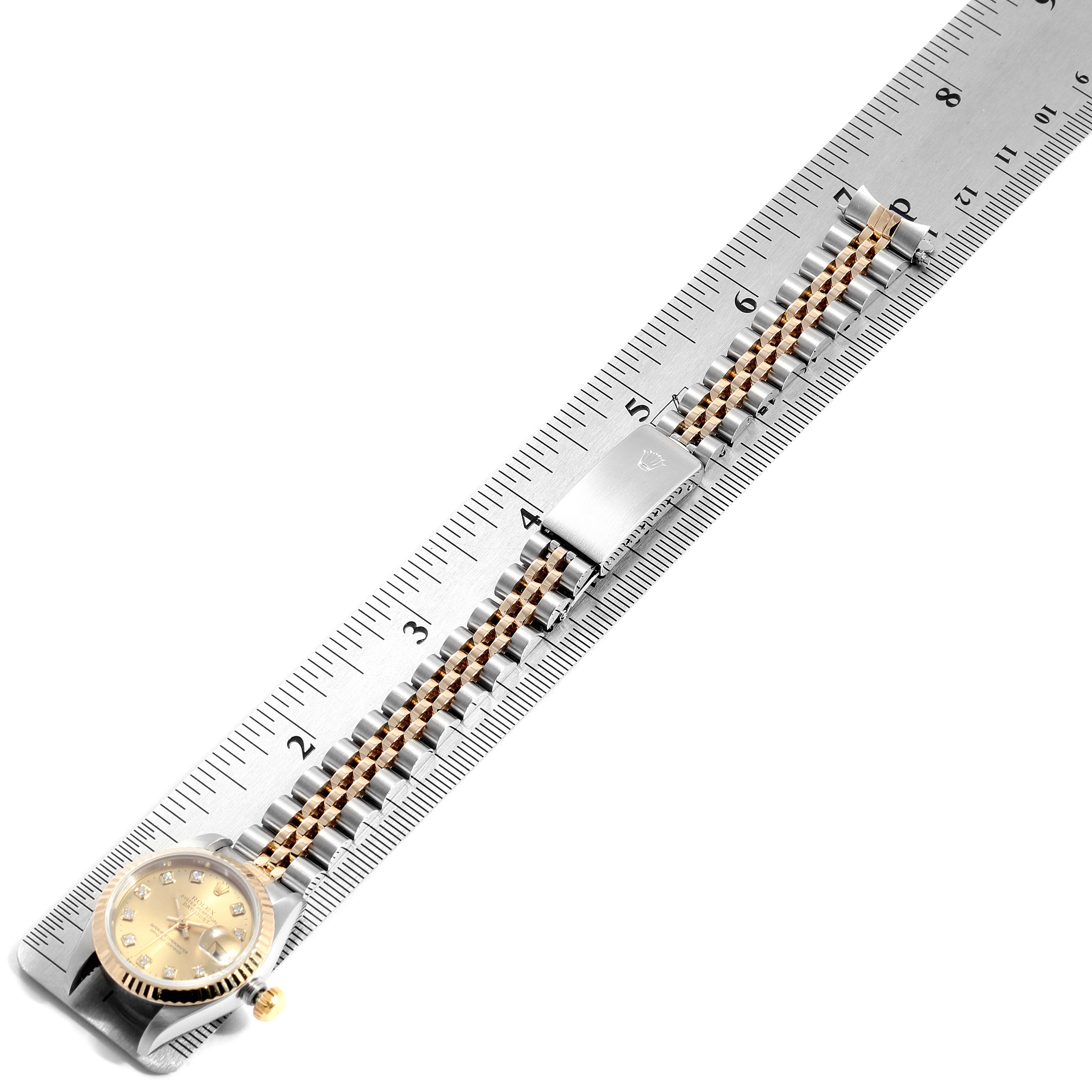 The image shows a top-down view of a Rolex Datejust 69173 Women
s Steel and Gold (two tone) Champagne Dial 69173 Women
s Steel and Gold (two tone) Champagne Dial watch with its band placed along a ruler for measurement.