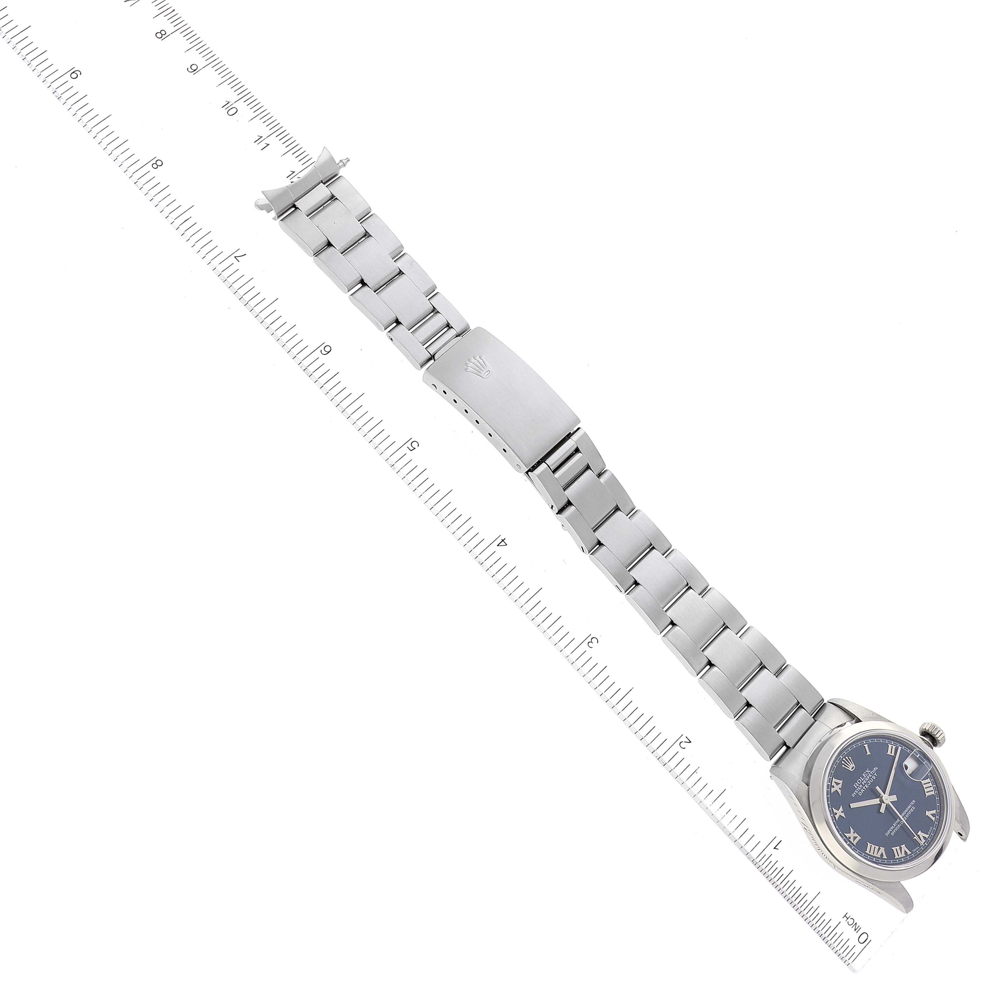 The Rolex Mid-Size 78240 Women
s Stainless Steel Blue Dial 78240 Women
s Stainless Steel Blue Dial model watch is shown from an overhead angle, displaying the face, bracelet, and clasp next to a ruler.