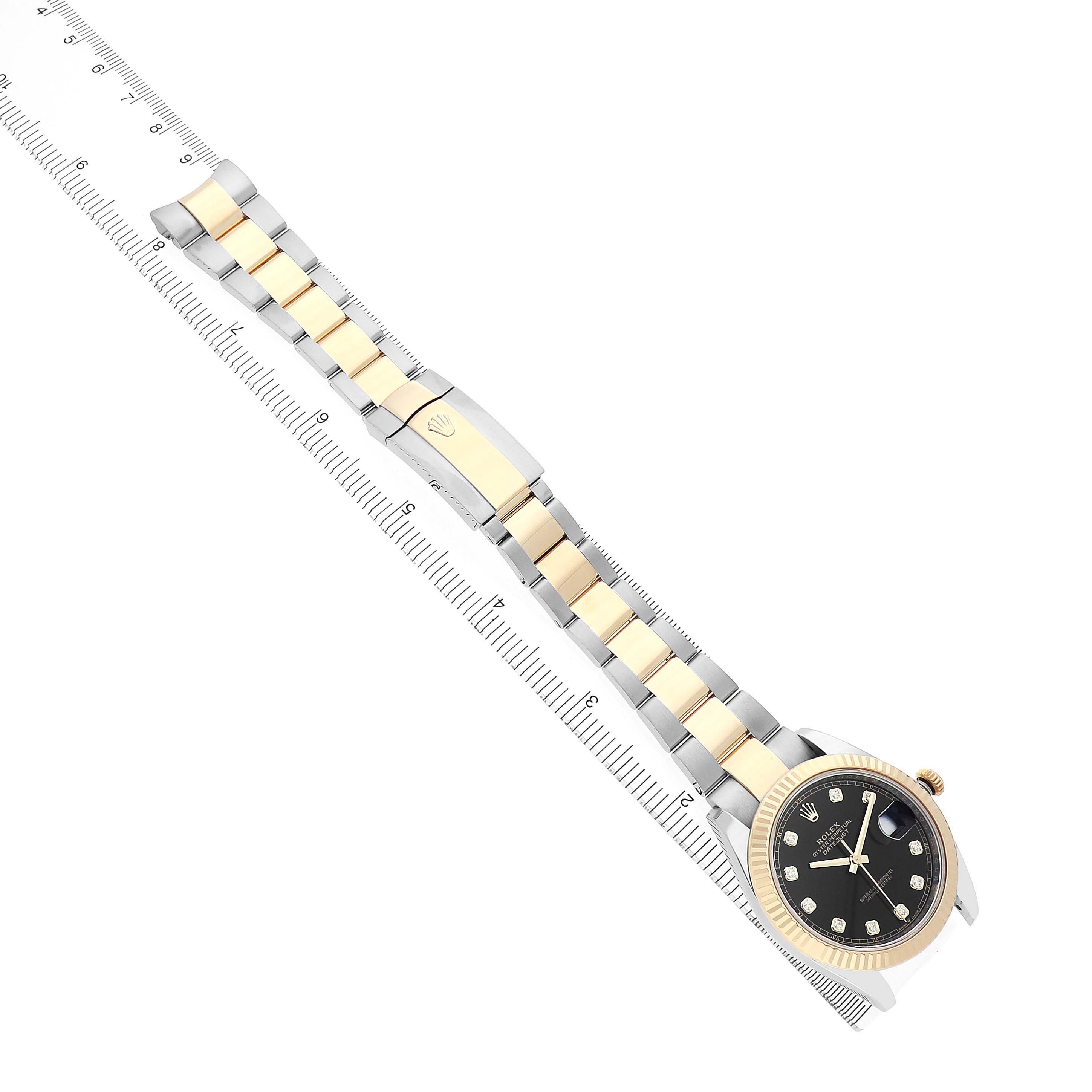 The Rolex Datejust 41 126333 Men's Steel and Gold (two tone) Black Dial is angled diagonally, showcasing the full bracelet and face, alongside a ruler for scale.