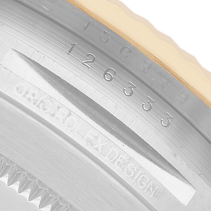 The image shows an angled close-up of the engraved inner bezel of a Rolex Datejust 41 126333 Men's Steel and Gold (two tone) Black Dial, featuring serial numbers and "ROLEX DESIGN".