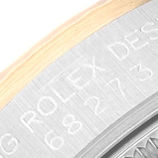 The image shows a close-up of the engraving on the bezel of a mid-size Rolex watch.