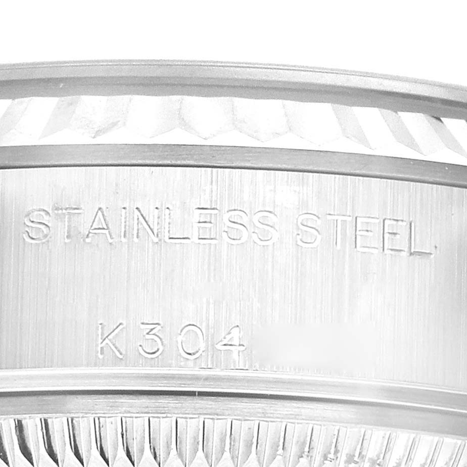 This image shows a close-up of the stainless steel back and part of the fluted bezel of a Rolex Datejust 79174 Women's Stainless Steel Pink Dial 79174 Women's Stainless Steel Pink Dial watch.