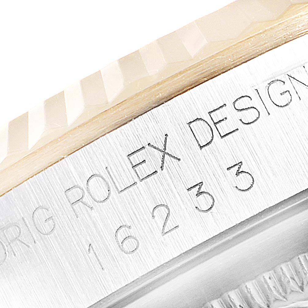 This close-up image shows the side of the Rolex Datejust 16233 Men
s Steel and Gold (two tone) Champagne Dial 16233 Men
s Steel and Gold (two tone) Champagne Dial watch with "ROLEX DESIGN" engraved.