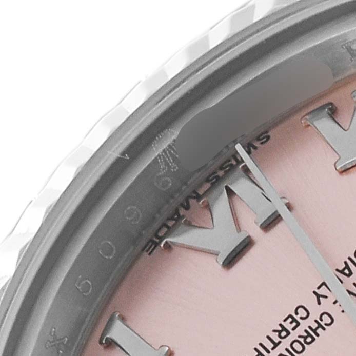 The close-up angle of the Rolex Datejust 179174 Women's Stainless Steel Pink Dial 179174 Women's Stainless Steel Pink Dial watch showcases the bezel, part of the dial, and Roman numerals.