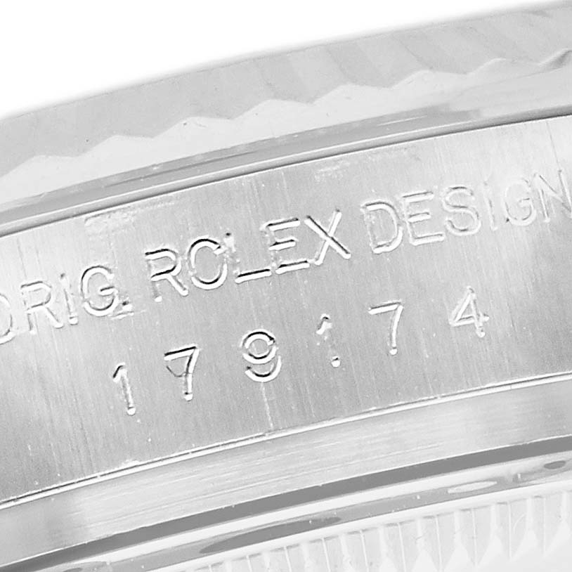 This image shows a close-up of the casing edge of a Rolex Datejust 179174 Women's Stainless Steel Pink Dial 179174 Women's Stainless Steel Pink Dial watch, displaying the engraved model number and "ORIG. ROLEX DESIGN."