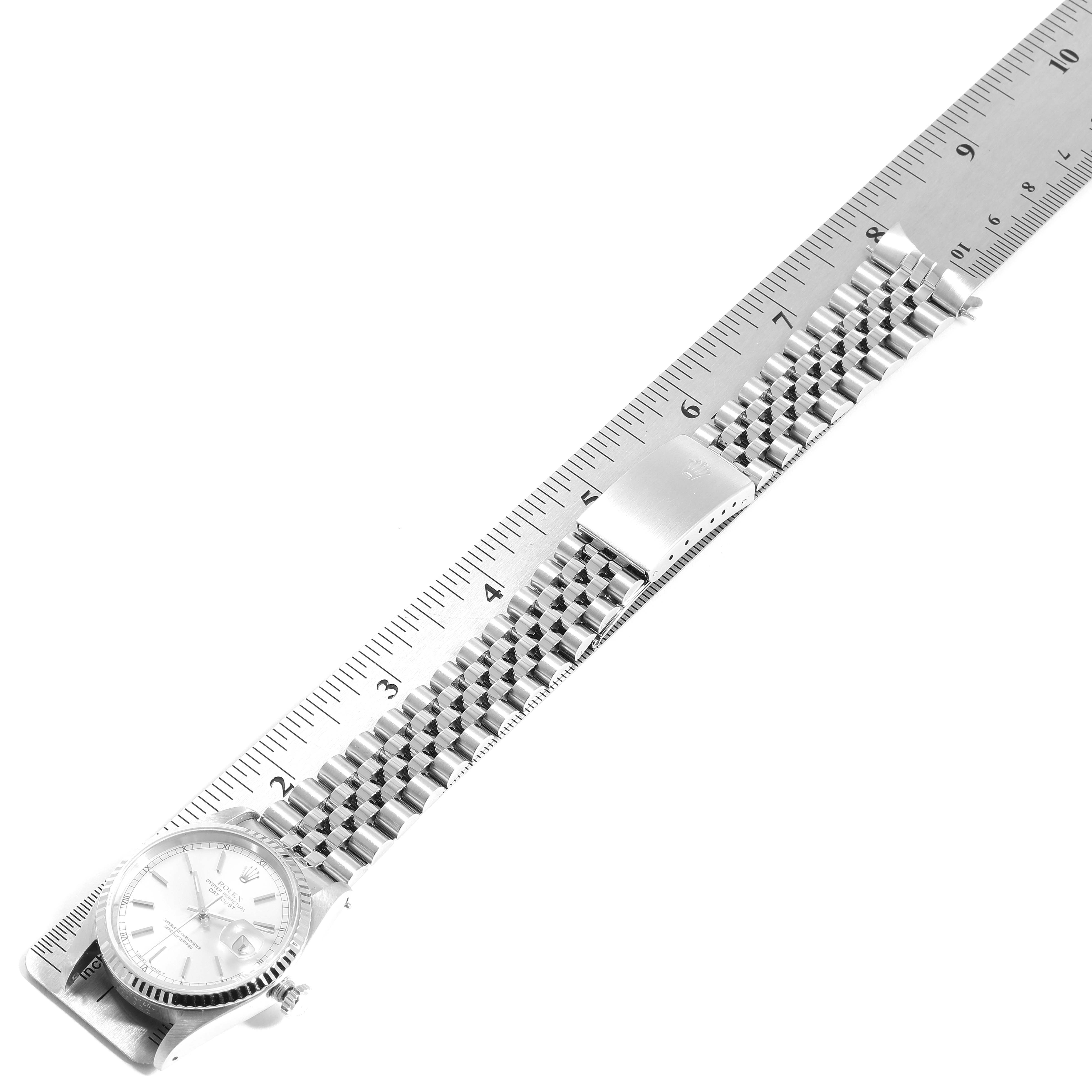 The image shows a Rolex Datejust 16234 Men's Stainless Steel Silver Dial 16234 Men's Stainless Steel Silver Dial watch from an angled top view, highlighting its face, bracelet, and clasp beside a ruler.