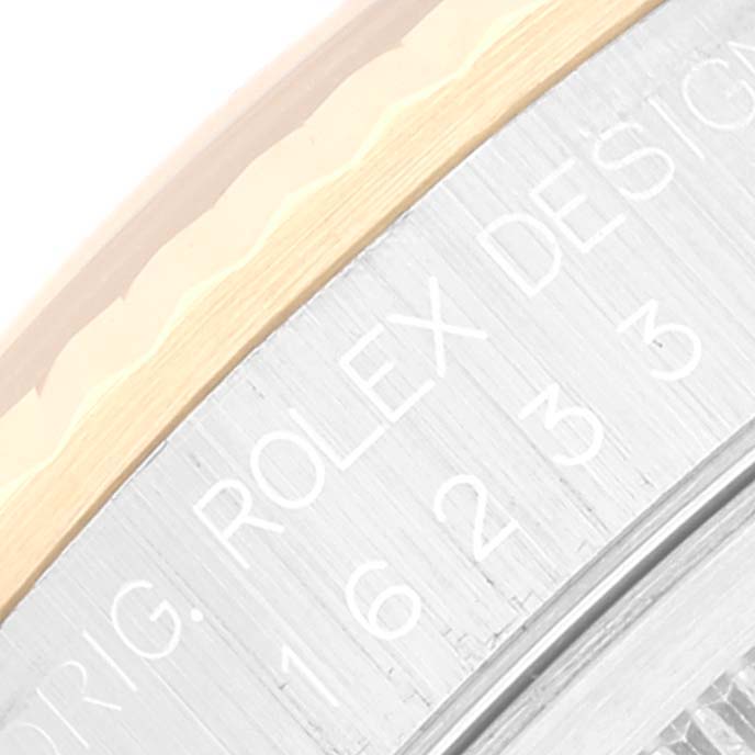 This close-up image shows part of the bezel and the engraved edge of the caseback of a Rolex Datejust 16233 Men's Steel and Gold (two tone) Black Dial 16233 Men's Steel and Gold (two tone) Black Dial watch.