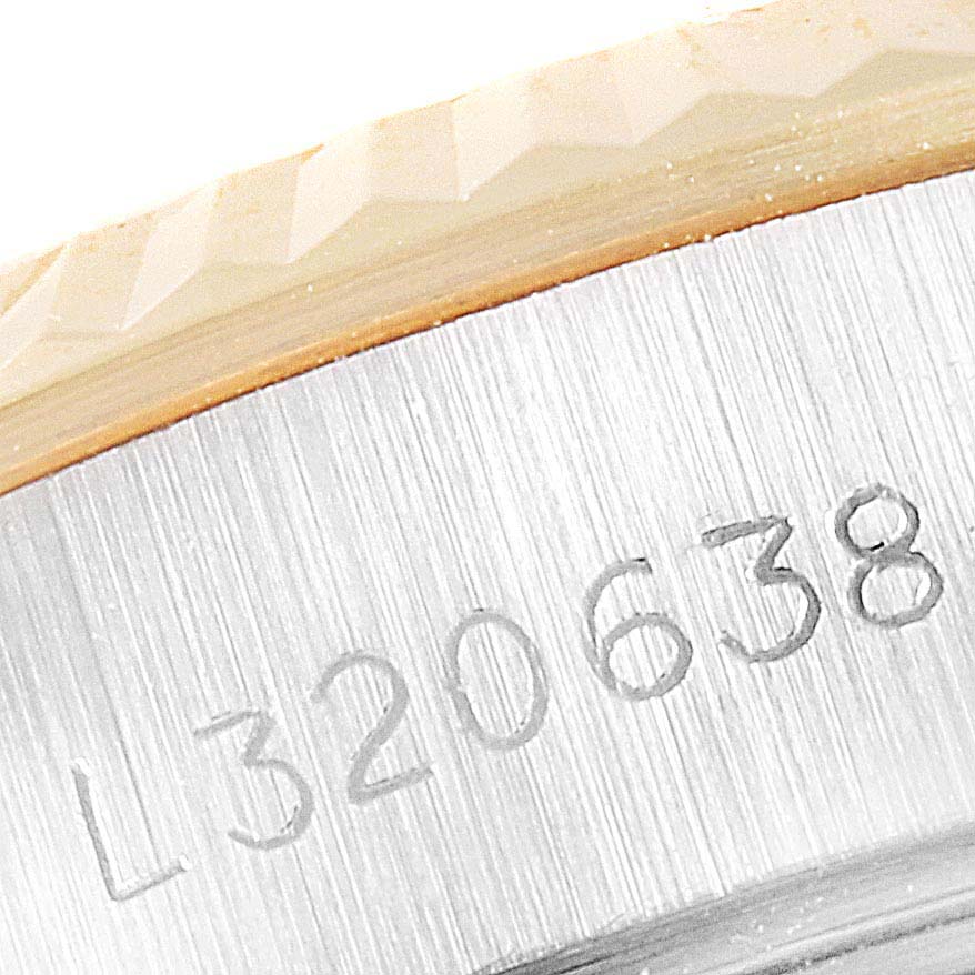 The image shows a close-up of the case
s serial number and part of the fluted bezel on a Rolex Datejust 69173 Women
s Steel and Gold (two tone) Champagne Dial 69173 Women
s Steel and Gold (two tone) Champagne Dial watch.