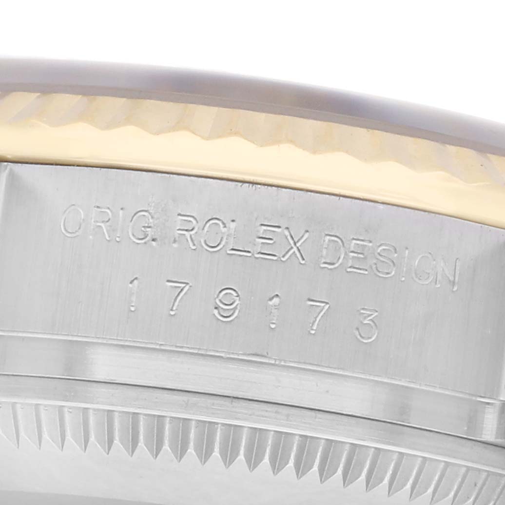 The image shows an angled close-up of the Rolex Datejust 179173 Women's Steel and Gold (two tone) White Dial 179173 Women's Steel and Gold (two tone) White Dial's engraved case edge with the model number.