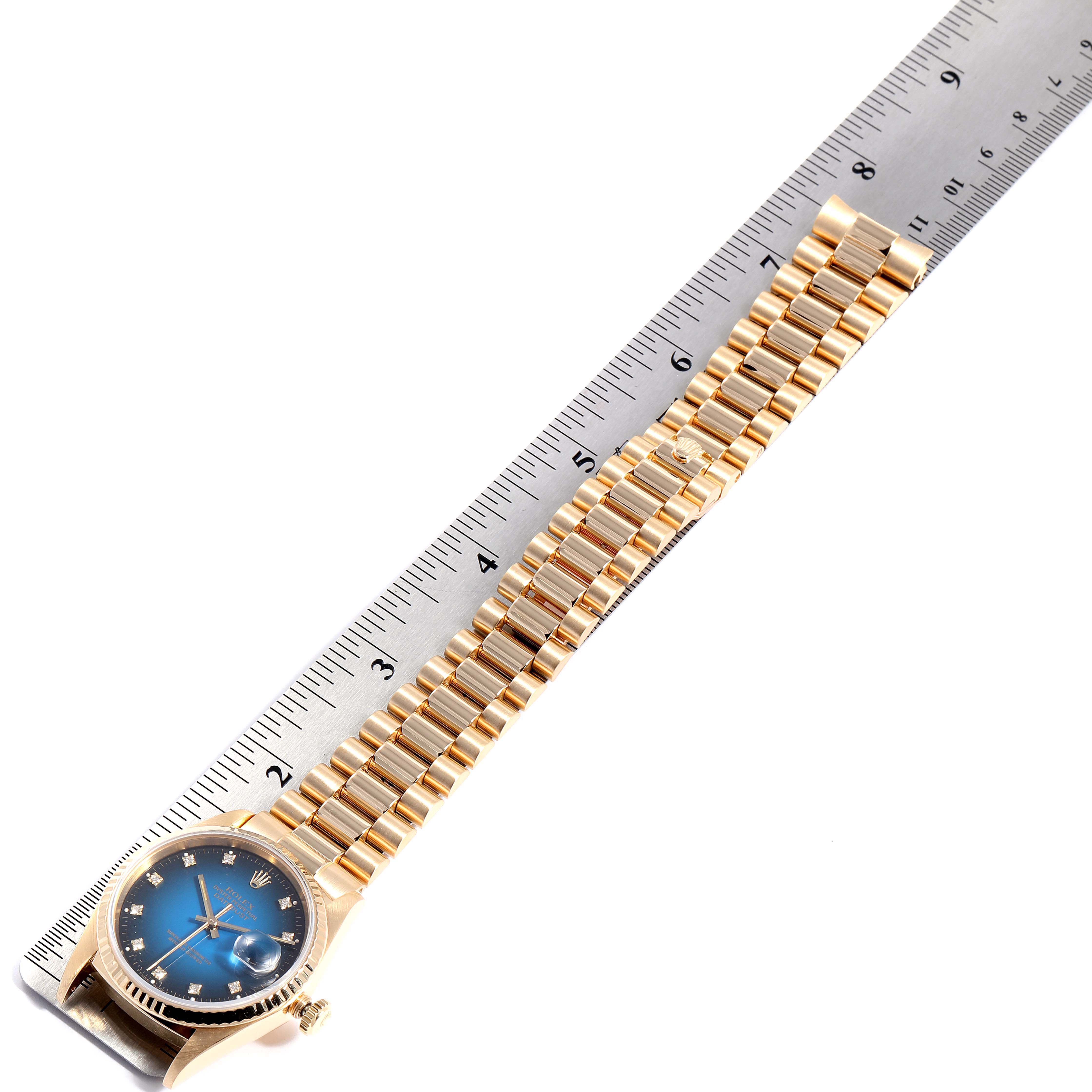 The image shows a Rolex President 16238 Men's Yellow Gold Blue Dial 16238 Men's Yellow Gold Blue Dial model watch laid flat against a ruler, highlighting the band and face at a slight angle.