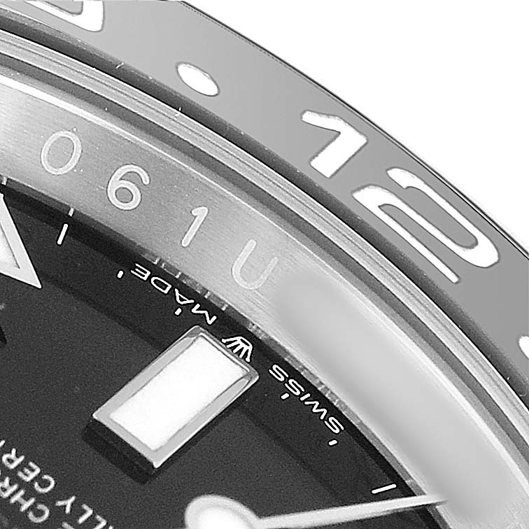 This close-up image of a Rolex GMT-Master 126710 Men's Stainless Steel Black Dial shows part of the dial, indices, bezel, and watch hands.