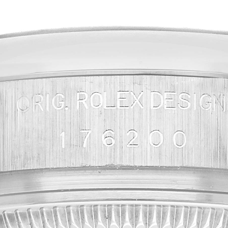 The image shows a close-up of the side of a Rolex Oyster Perpetual 176200 Women's Stainless Steel Blue Dial 176200 Women's Stainless Steel Blue Dial watch case with engraved model details.