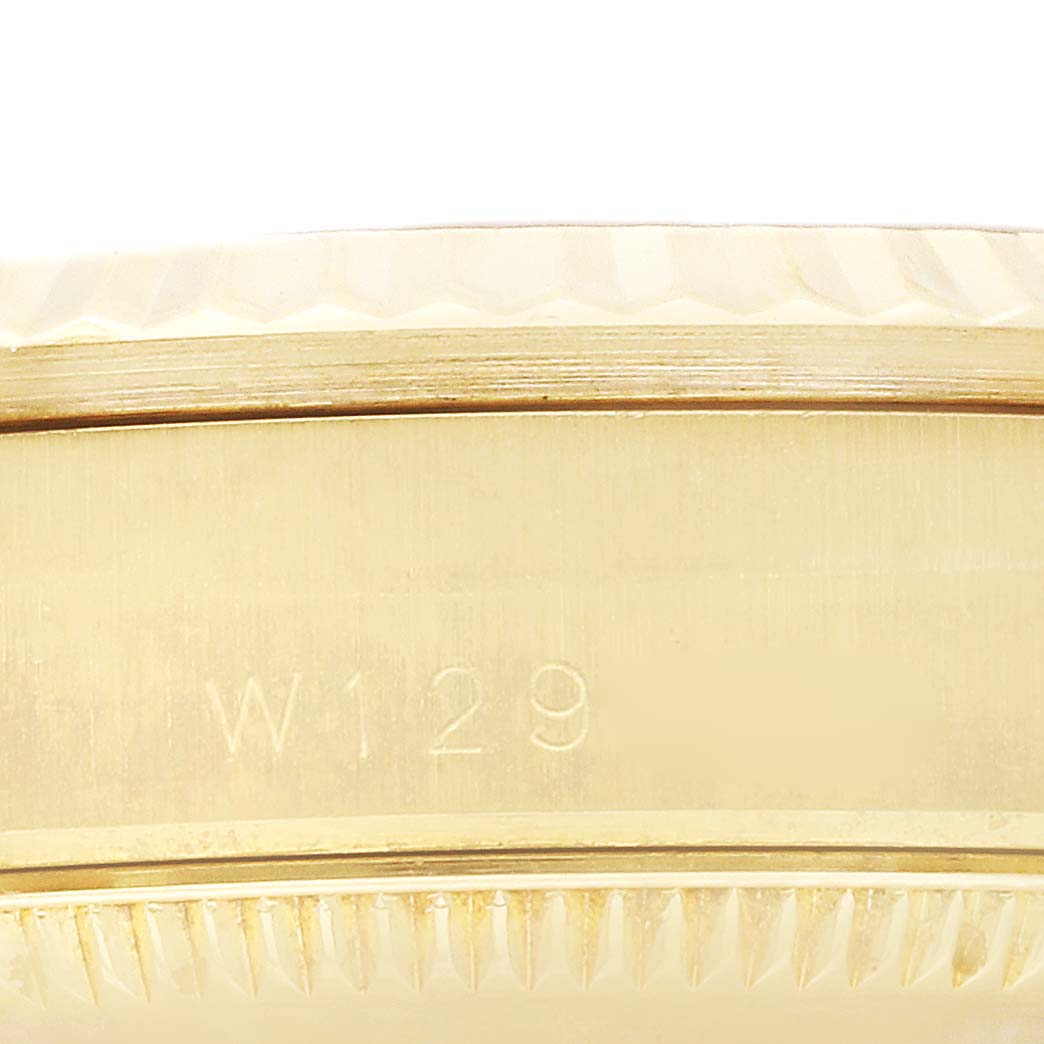 This image shows a close-up of the side of a Rolex President 68278 Women's Yellow Gold Champagne Dial 68278 Women's Yellow Gold Champagne Dial Model watch, highlighting the watch case and part of the bezel with an engraved number "W129".