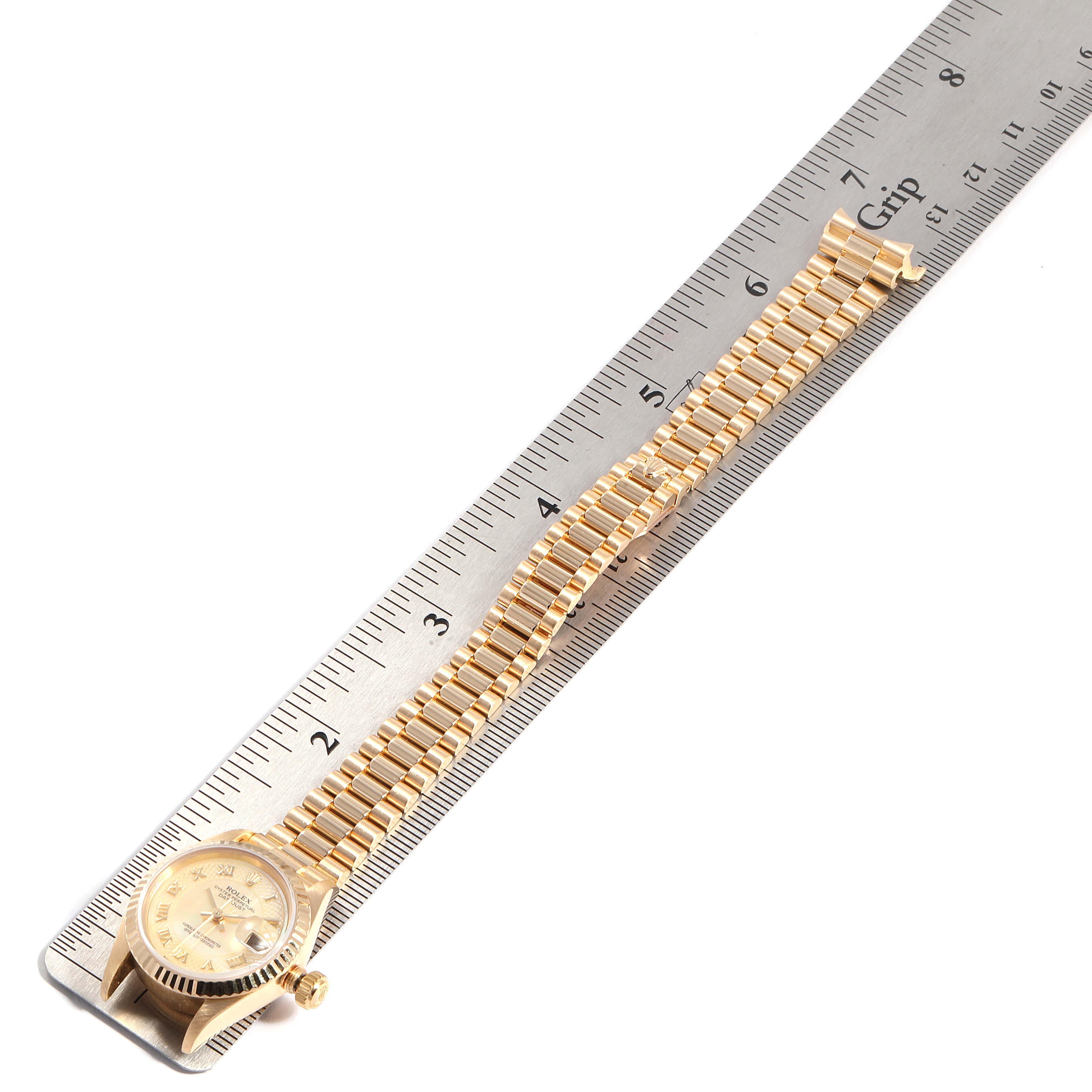 The President model by Rolex is shown from a top-down angle, alongside a measurement ruler.