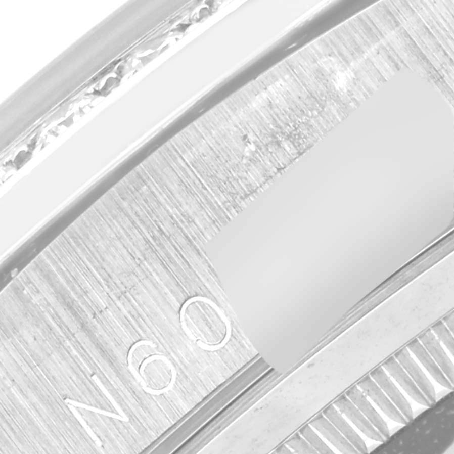 The image shows a close-up of the bezel and part of the case of a Rolex President 18389MG Men's White Gold Silver Dial 18389MG Men's White Gold Silver Dial model watch.