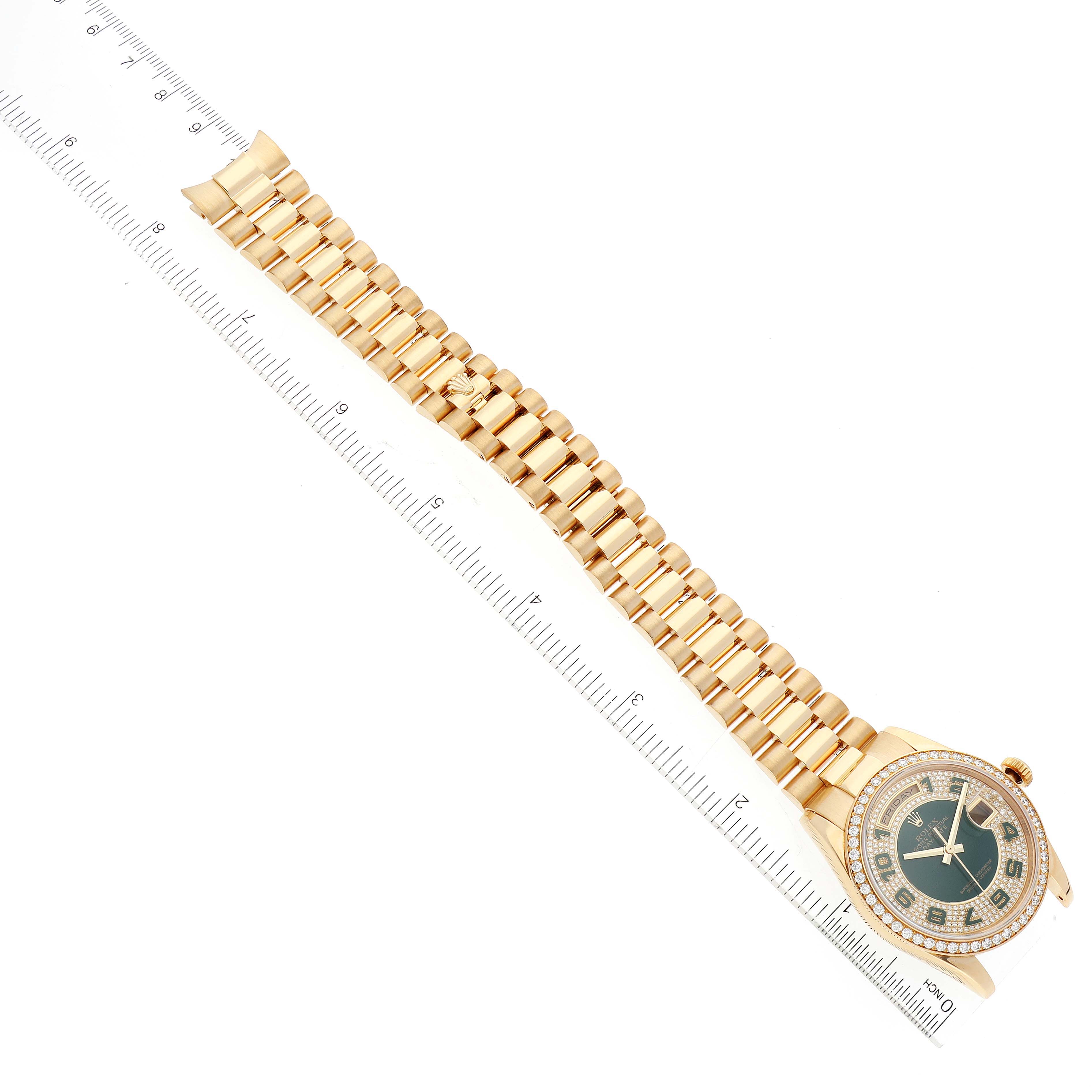 The Rolex President 118348 Men's Yellow Gold Green Dial model watch is shown from a top-down view, highlighting the full bracelet and watch face alongside a ruler.
