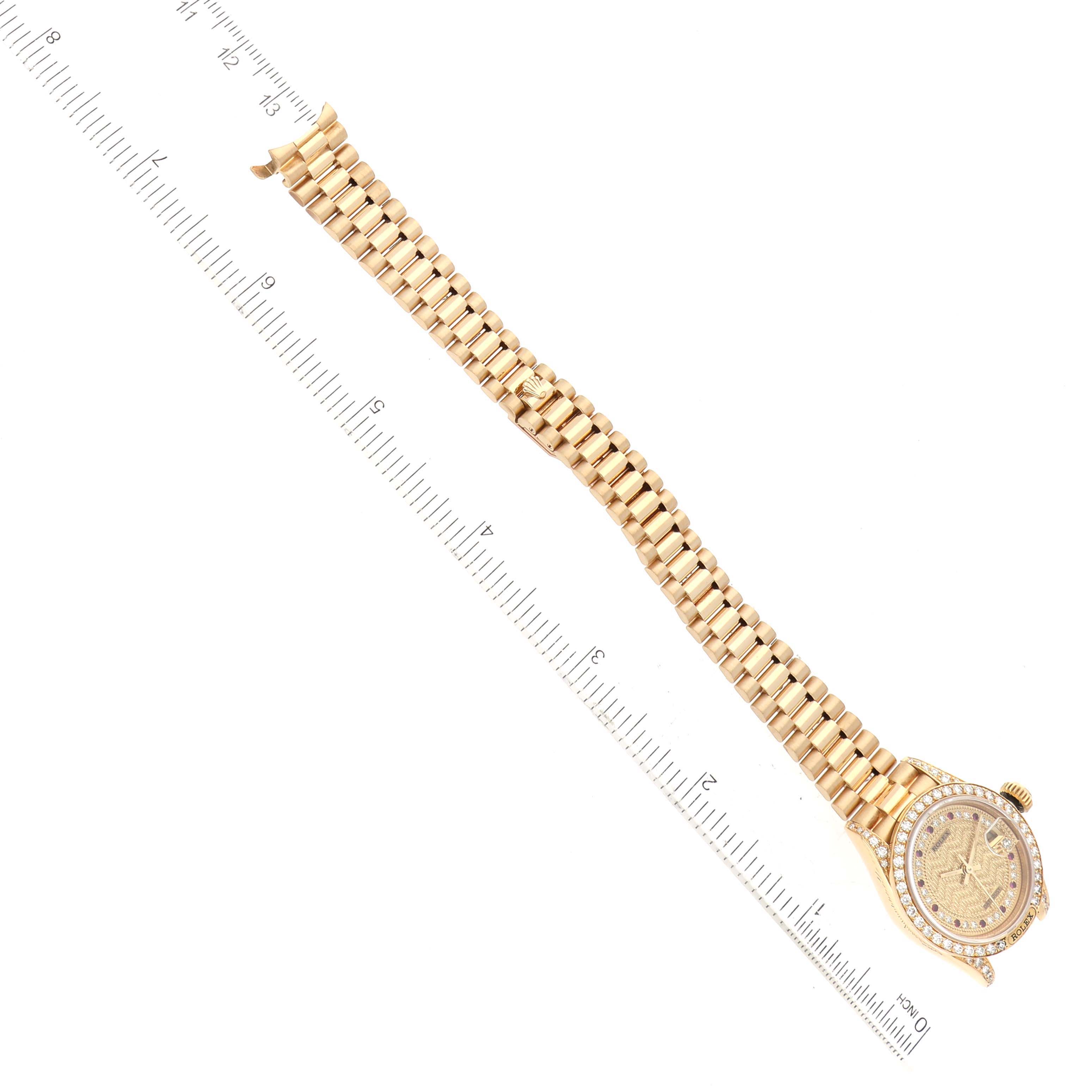 The image shows the Rolex President 69158 Women's Yellow Gold Champagne Dial 69158 Women's Yellow Gold Champagne Dial model watch laid flat with a full view of the band, case, and bezel, alongside a ruler for scale.