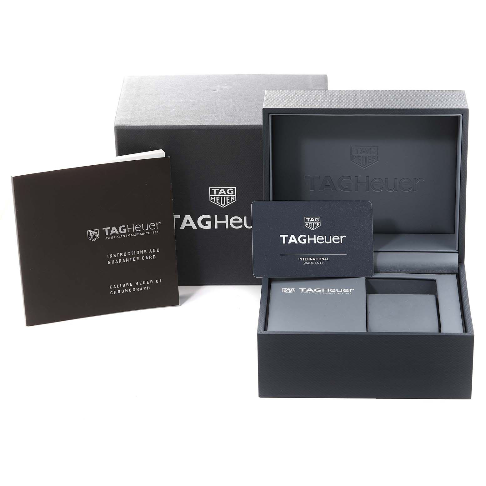 The image shows the packaging, instruction manual, guarantee card, and warranty card for the Tag Heuer Carrera CAR2A1W Men's Stainless Steel Transparent Dial CAR2A1W Men's Stainless Steel Transparent Dial watch.