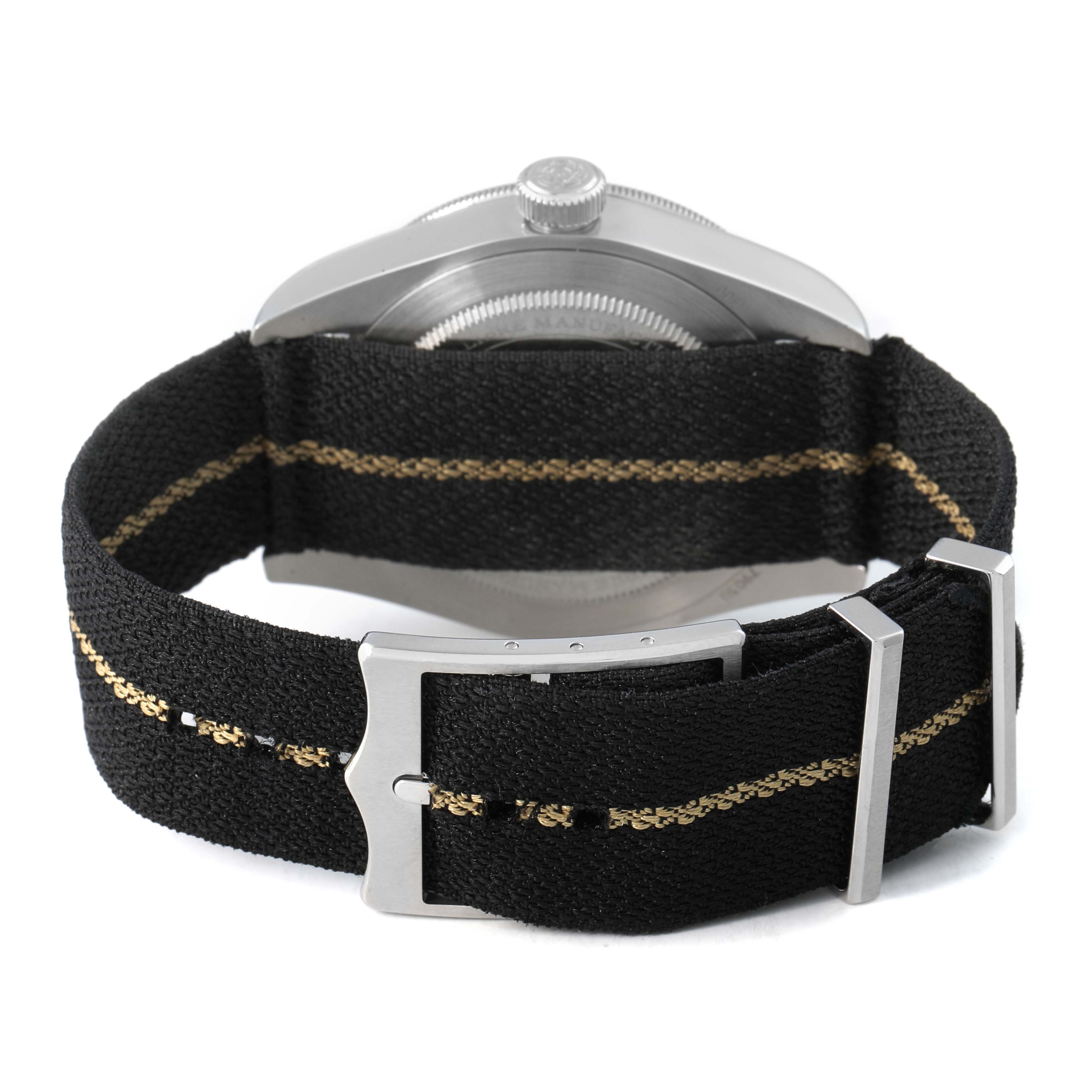 The image shows the back view of a Tudor Heritage Black Bay 79030 Men's Stainless Steel Black Dial watch with its fabric strap and buckle visible.