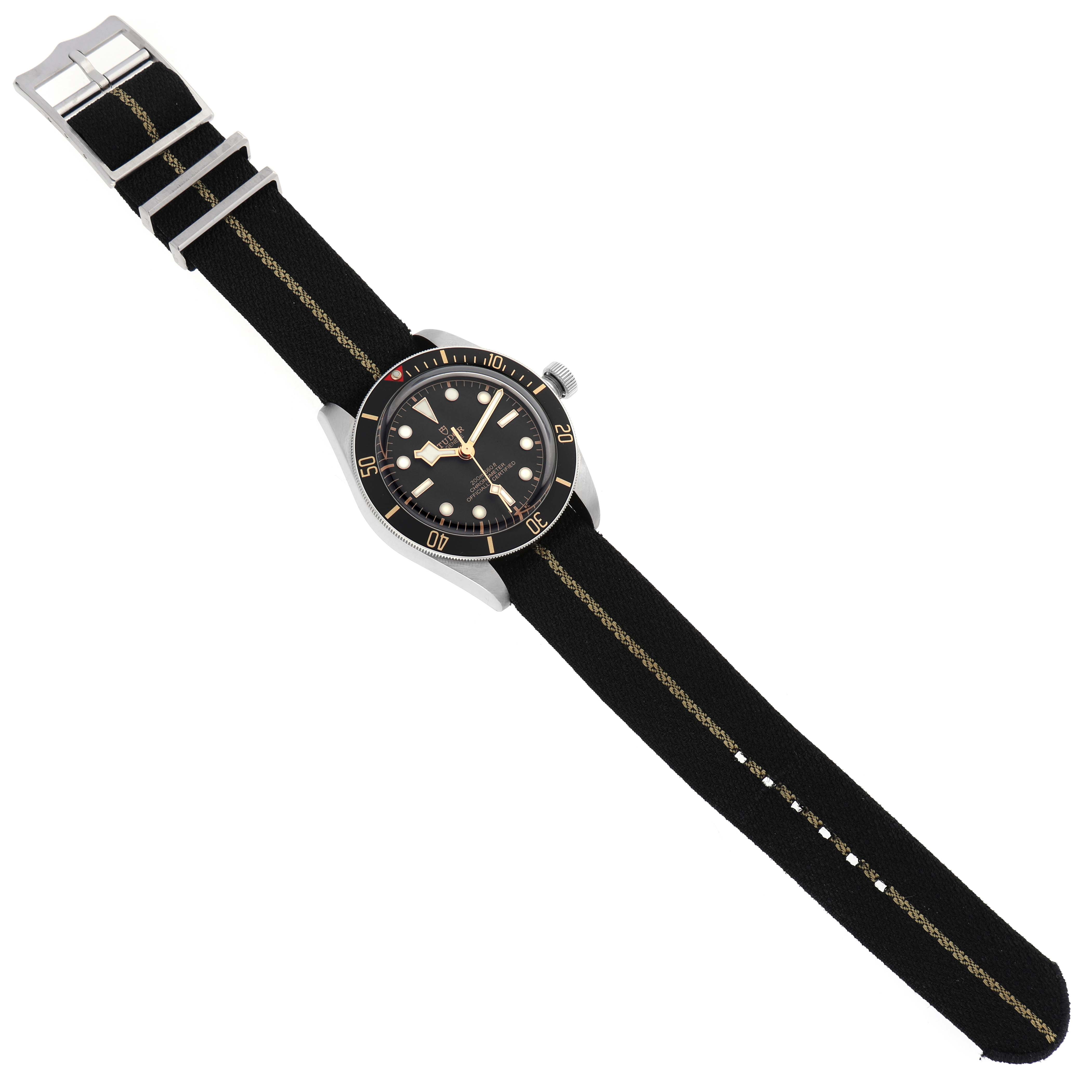 The Tudor Heritage Black Bay 79030 Men's Stainless Steel Black Dial watch is shown at an angled top view, featuring its face, bezel, crown, and strap.