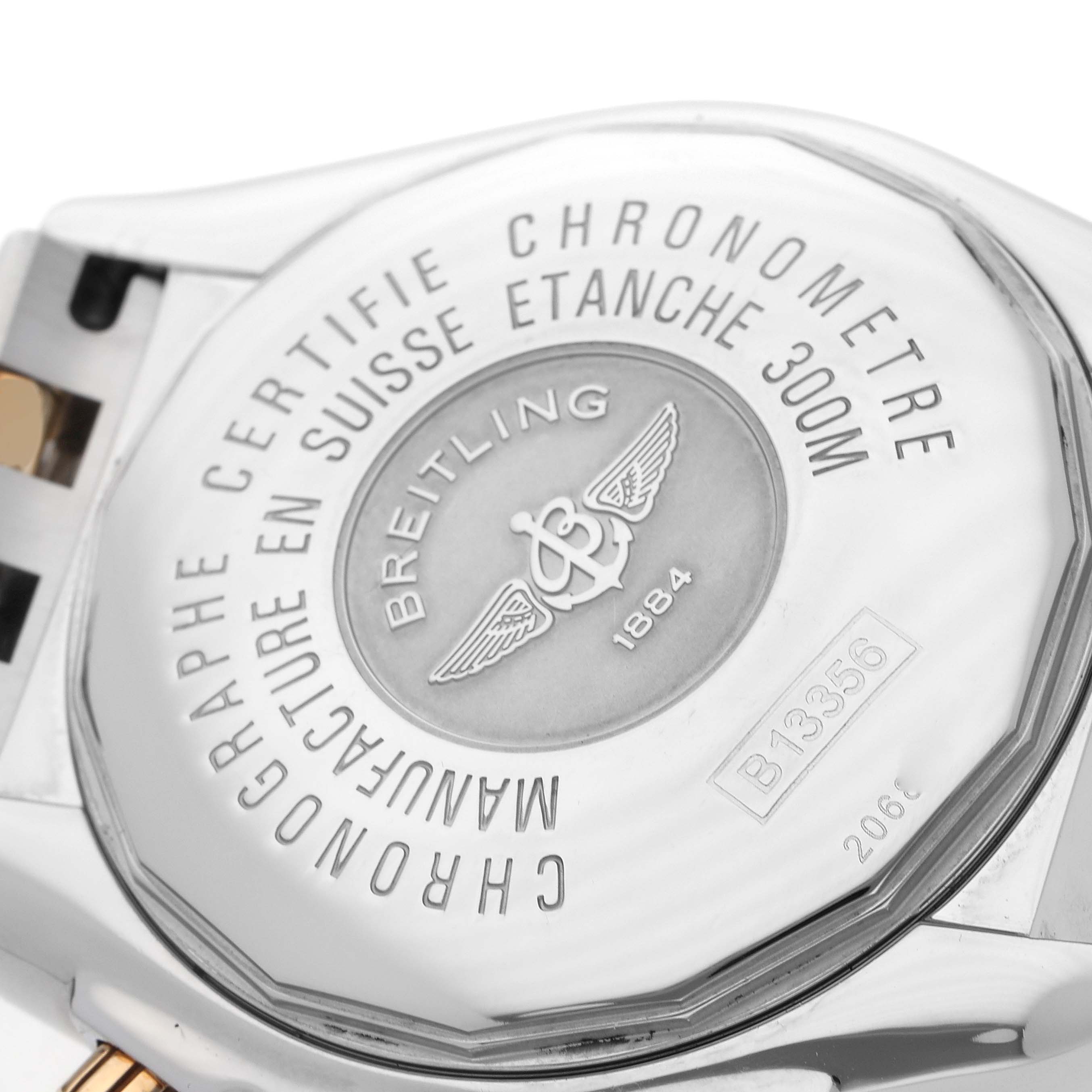 The image shows the back case of a Breitling Chronomat B13356 Men's Steel and Gold (two tone) Black Dial B13356 Men's Steel and Gold (two tone) Black Dial watch, highlighting the brand engraving and specifications.