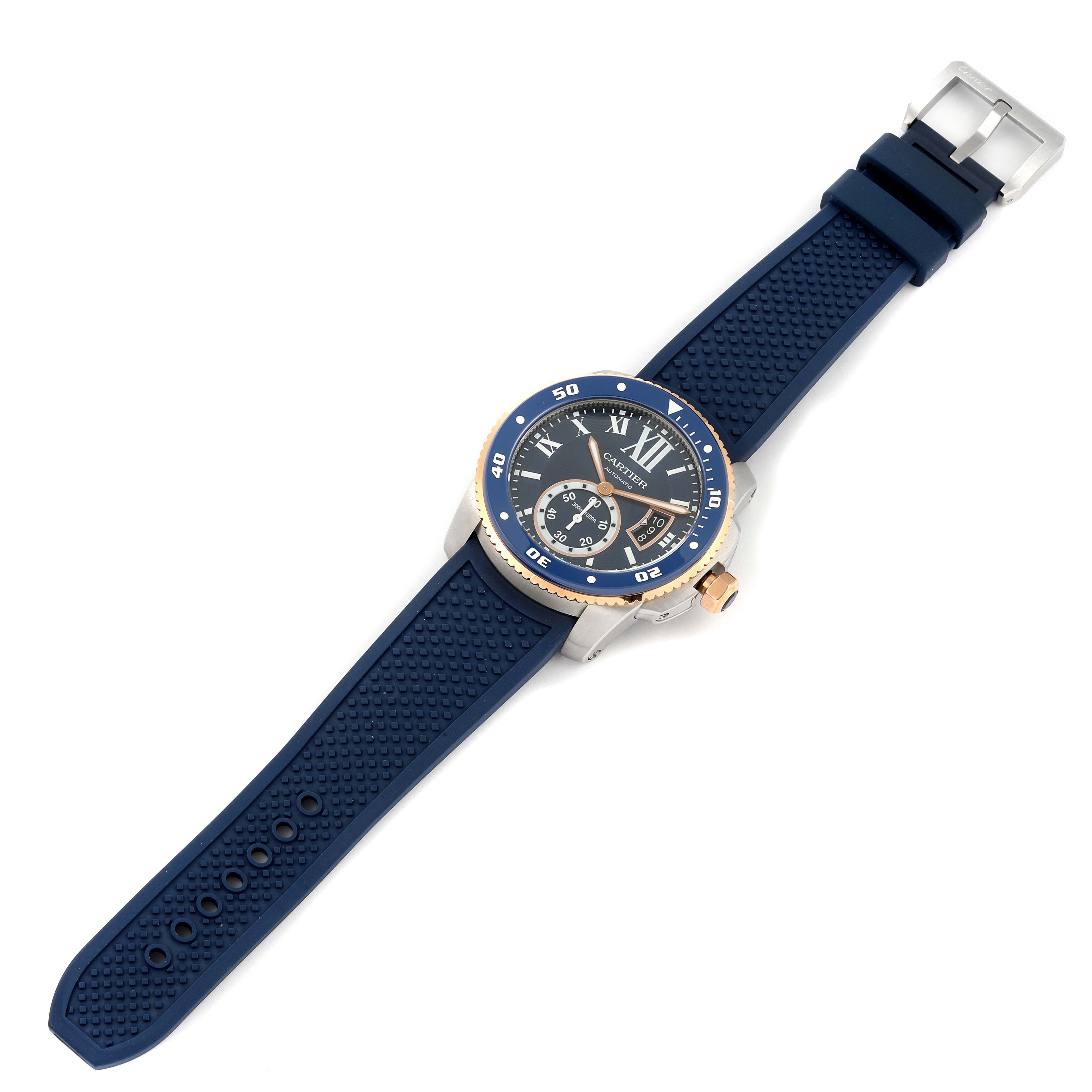 The image shows a top-down view of a Calibre de Cartier watch by Cartier, featuring a blue strap and a detailed face including a round bezel.