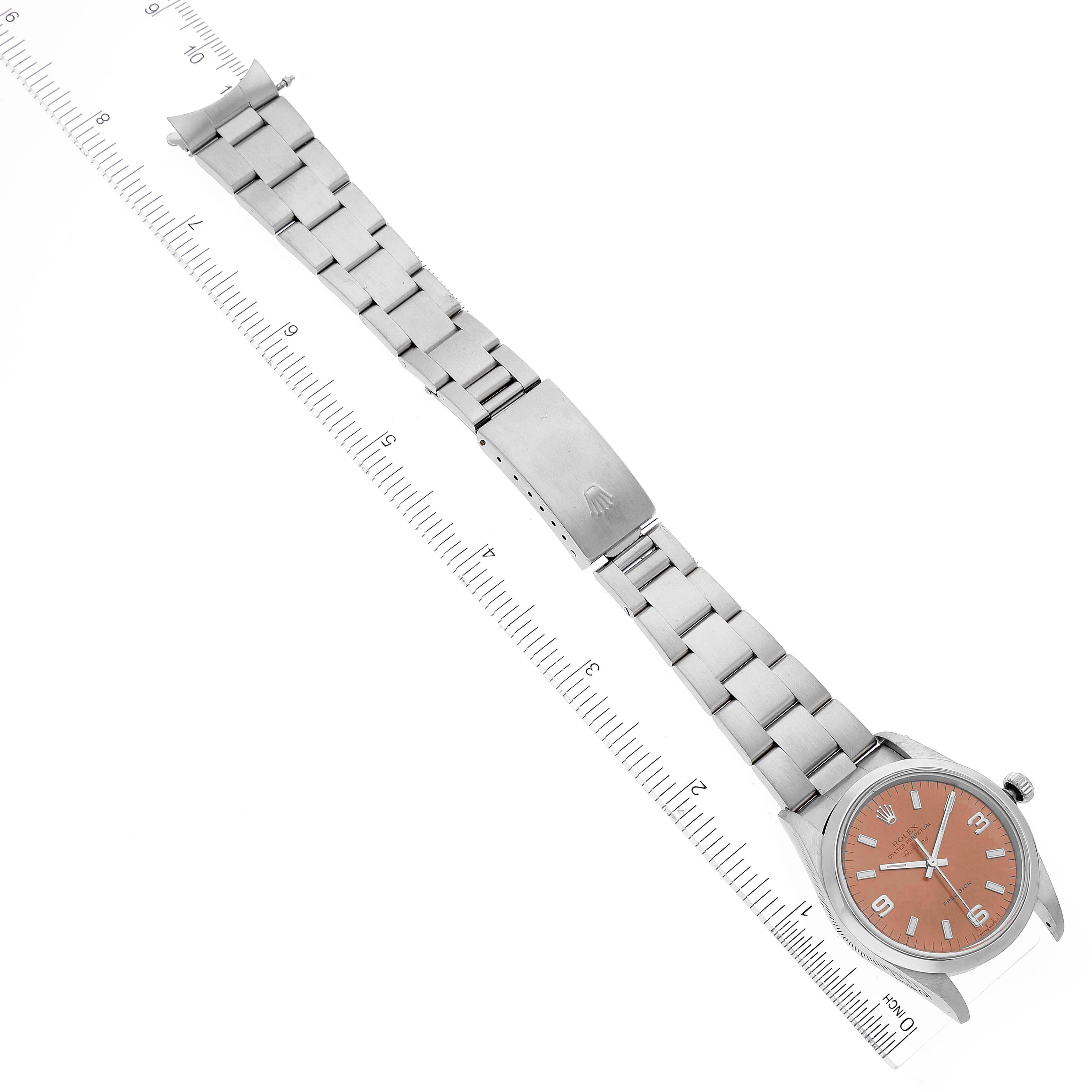 The image shows a Rolex Air-King 14000 Men's Stainless Steel Pink Dial 14000 Men's Stainless Steel Pink Dial watch laid flat with an orange dial and stainless steel bracelet, alongside a ruler for scale.