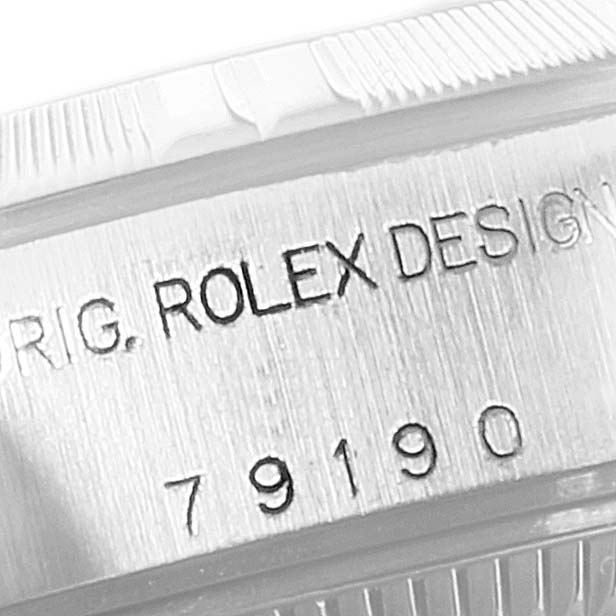 The image shows a close-up of the serial number engraving on a Rolex Date 79190 Women's Stainless Steel Blue Dial 79190 Women's Stainless Steel Blue Dial model watch case.