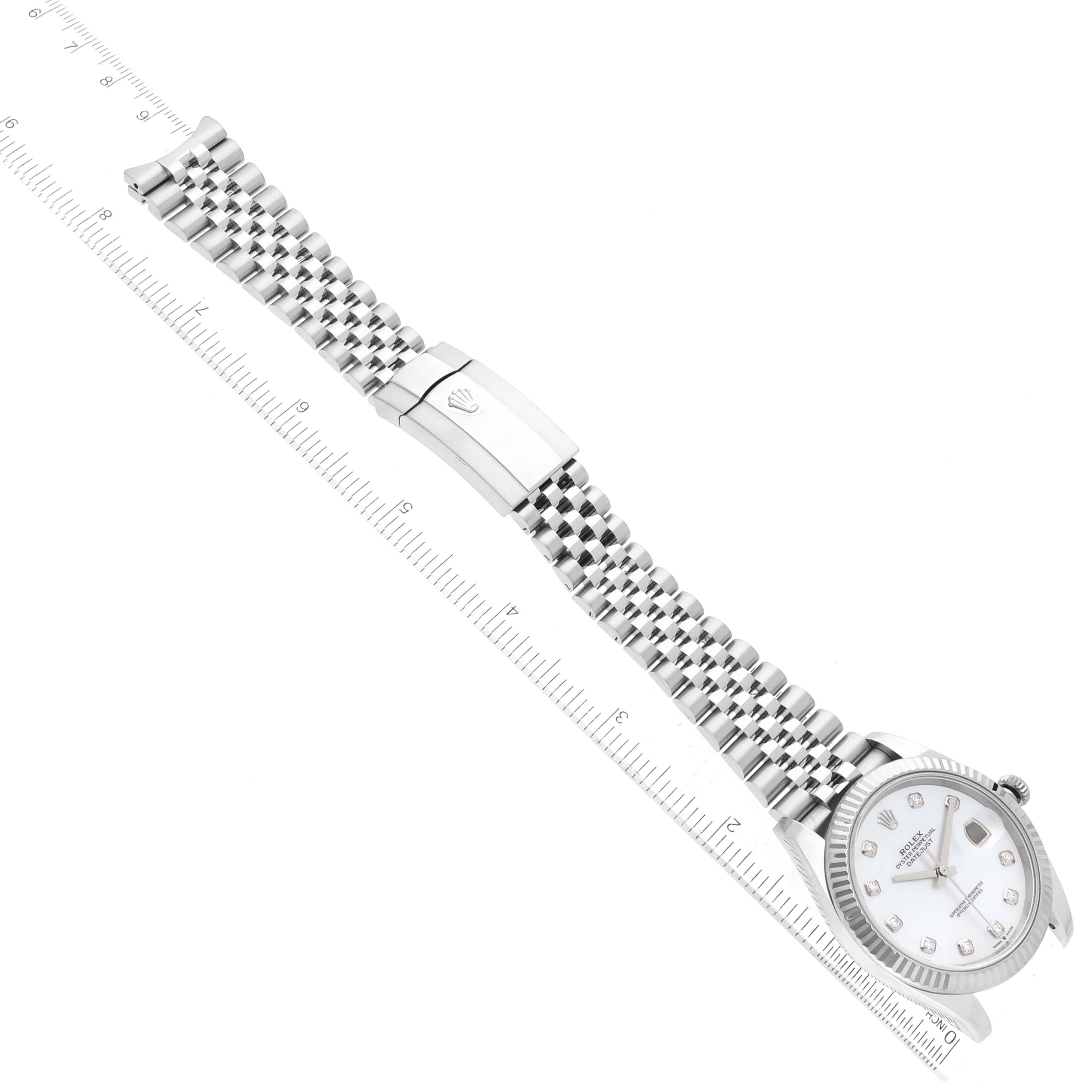 The image shows a Rolex Datejust 41 126334 Men
s Stainless Steel Mother of Pearl Dial 126334 Men
s Stainless Steel Mother of Pearl Dial watch laid flat with the entire bracelet and face visible alongside a ruler.