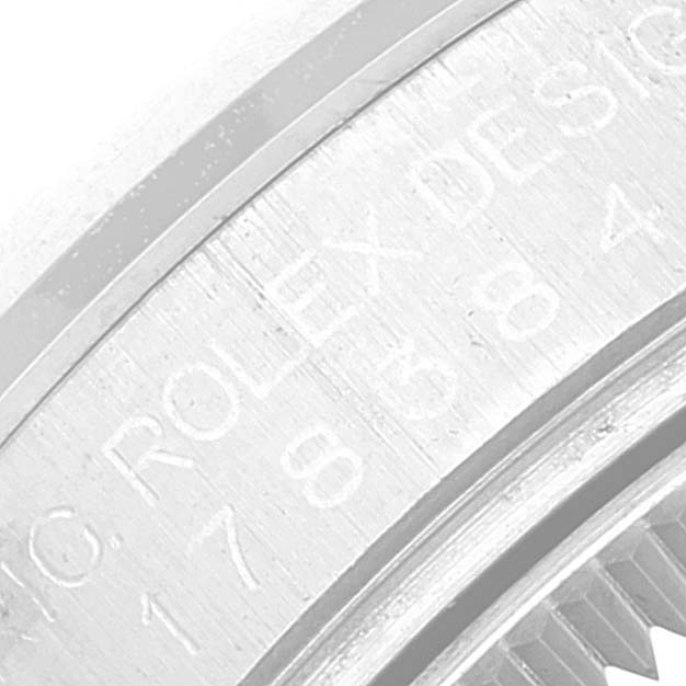 This image shows an extreme close-up of the engraved serial number on the bezel of a Mid-Size Rolex watch.