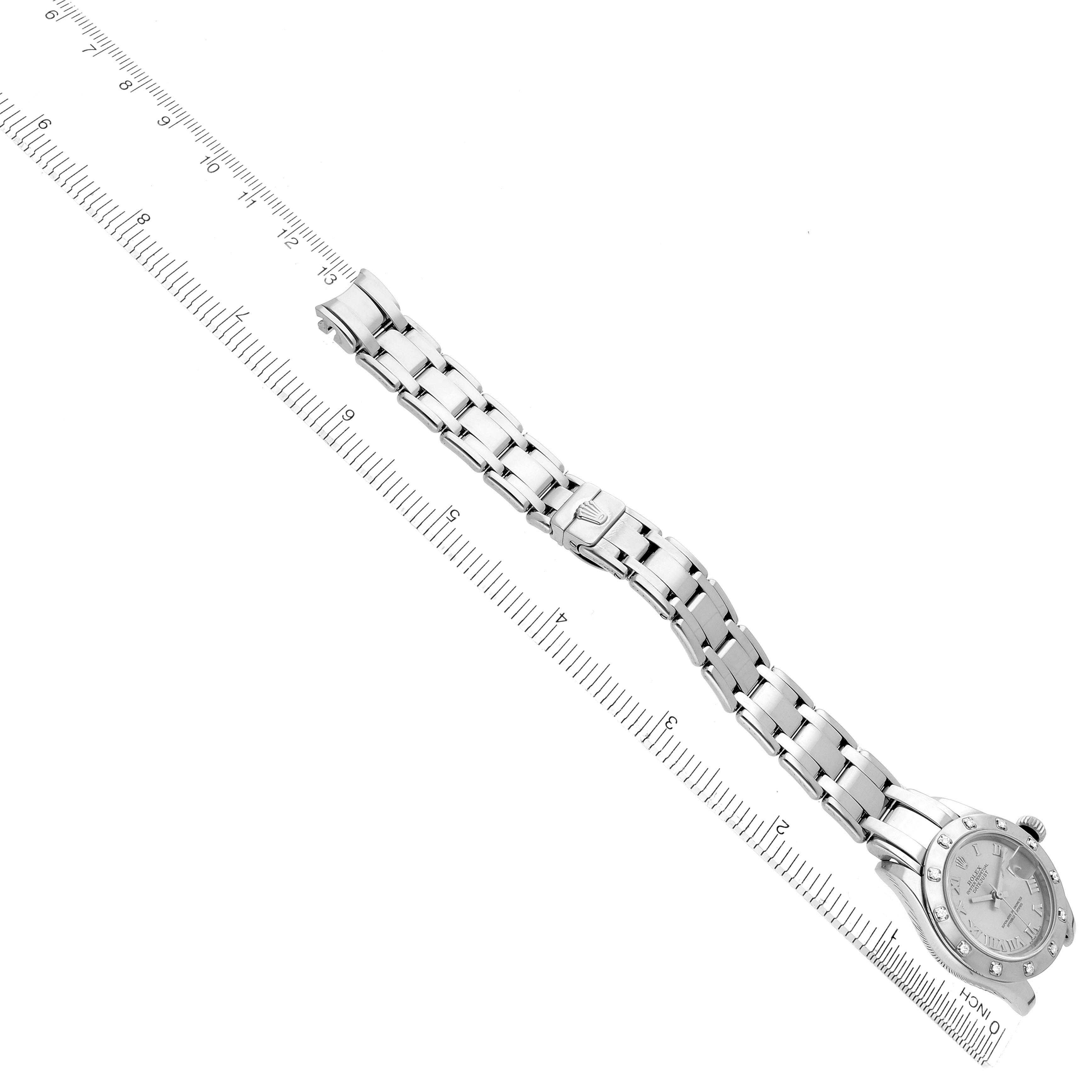 The Rolex Pearlmaster 80319 Women
s White Gold Silver Dial 80319 Women
s White Gold Silver Dial watch is shown at an angle, displaying the bracelet, clasp, and face alongside a measuring ruler.