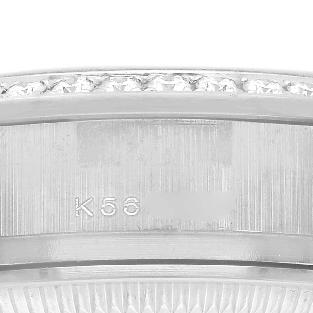 The image shows a close-up of the Rolex President 179159 Women
s Platinum Blue Dial 179159 Women
s Platinum Blue Dial model
s bezel with diamond detailing and engraved serial number.