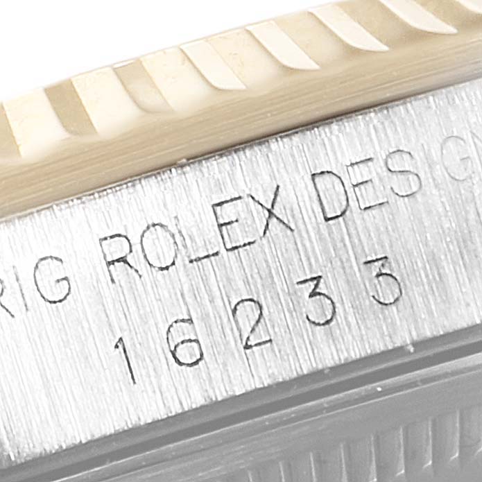 Close-up of the side of a Rolex Datejust 16233 Men's Steel and Gold (two tone) Black Dial 16233 Men's Steel and Gold (two tone) Black Dial showing part of the fluted bezel and engraved model number "16233."