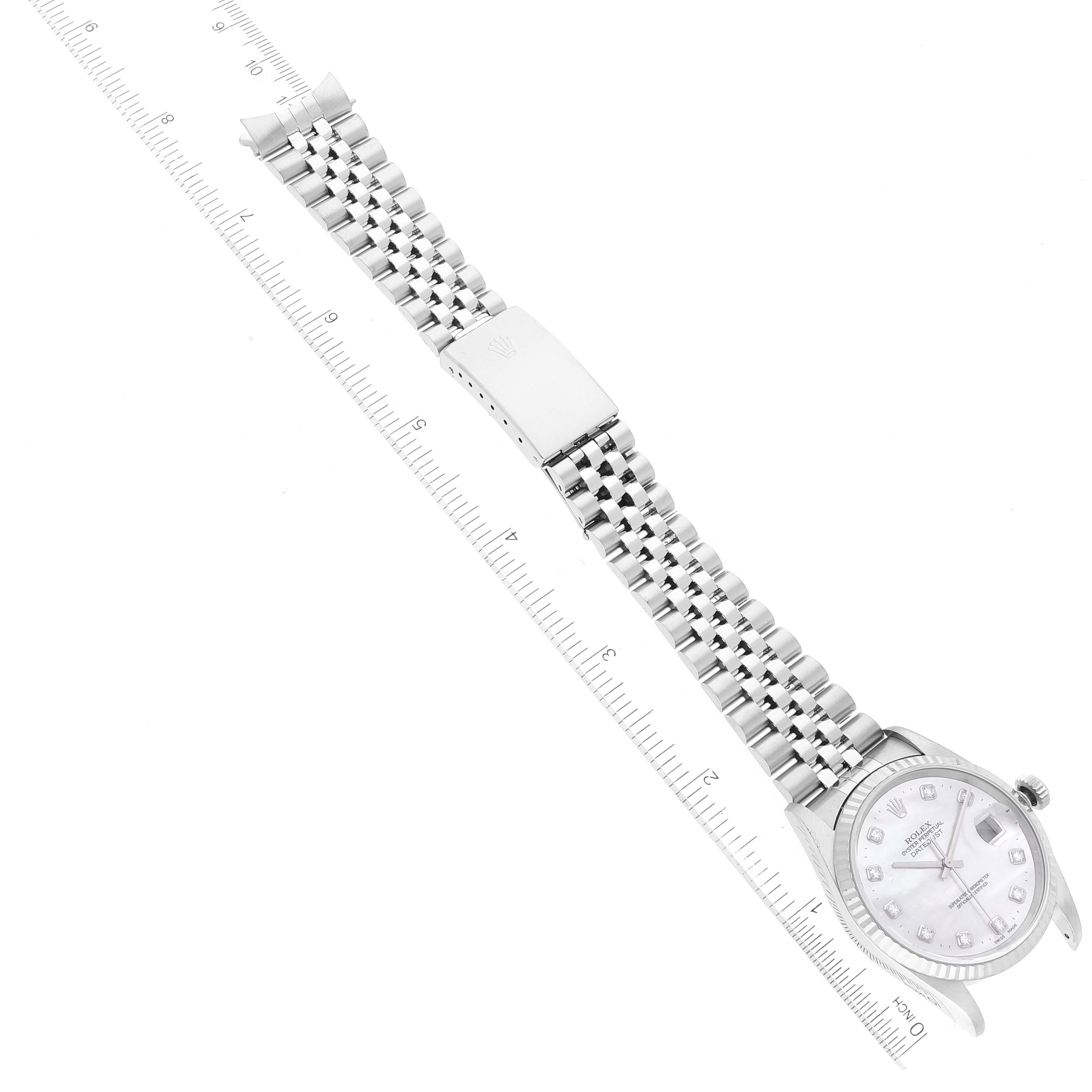 The image shows a top view of a Rolex Datejust 16234 Men's Stainless Steel Mother of Pearl Dial 16234 Men's Stainless Steel Mother of Pearl Dial watch, displaying its face, bracelet, and clasp, aligned with a ruler for scale.