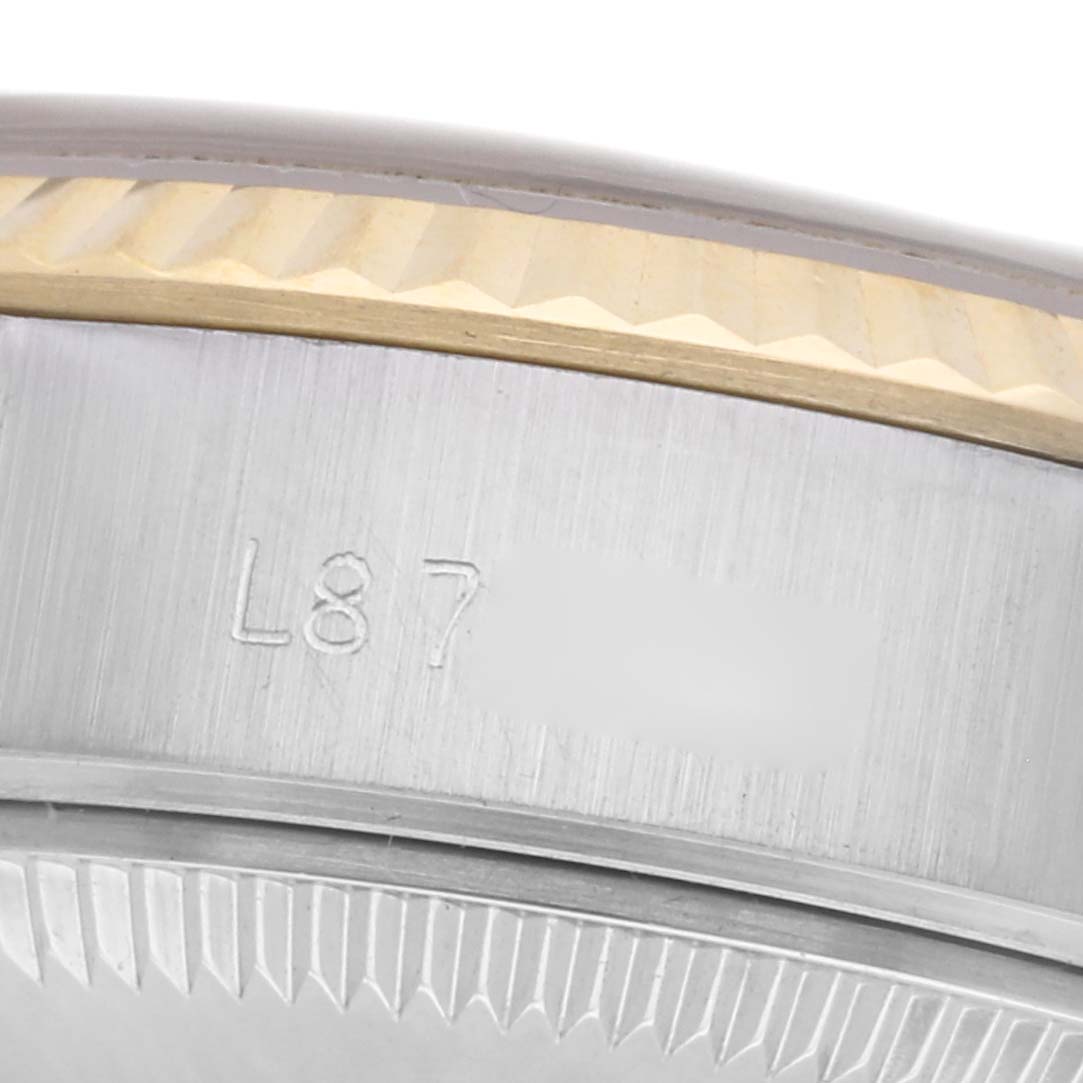 The image shows a close-up side view of the Rolex Datejust 69173 Women
s Steel and Gold (two tone) Champagne Dial 69173 Women
s Steel and Gold (two tone) Champagne Dial watch
s bezel and case with engraved markings.