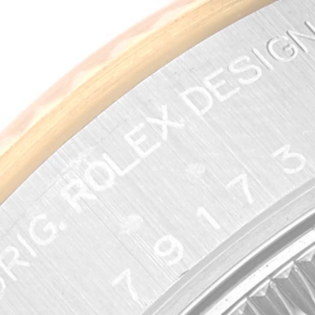 This close-up image of a Rolex Datejust 79173 Women's Steel and Gold (two tone) Champagne Dial 79173 Women's Steel and Gold (two tone) Champagne Dial watch shows part of the case with engraved text reading "ORIG. ROLEX DESIGN."