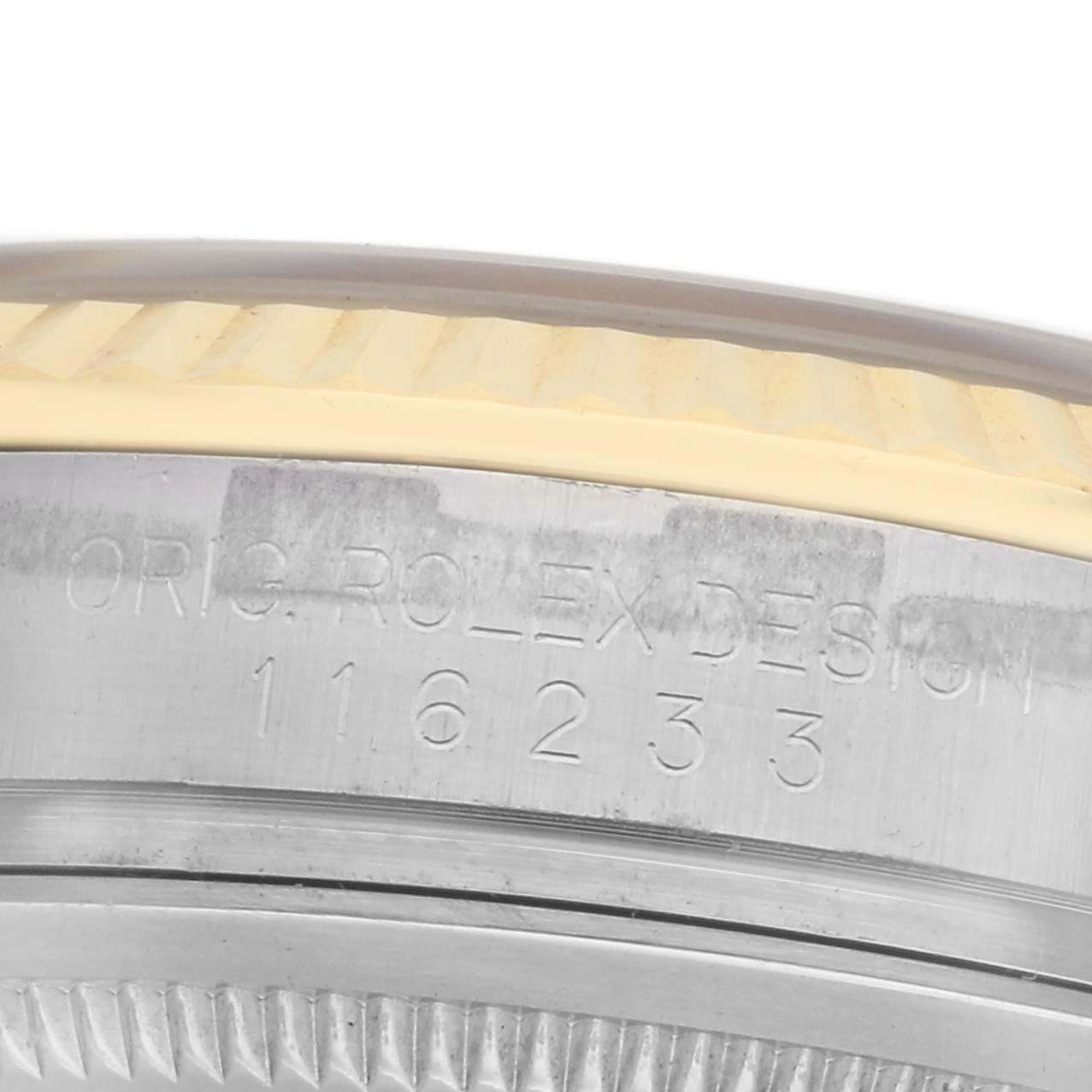 The image shows a close-up view of the Rolex Datejust 116233 Men's Steel and Gold (two tone) Champagne Dial 116233 Men's Steel and Gold (two tone) Champagne Dial watch's bezel, edge, and engraved model number.