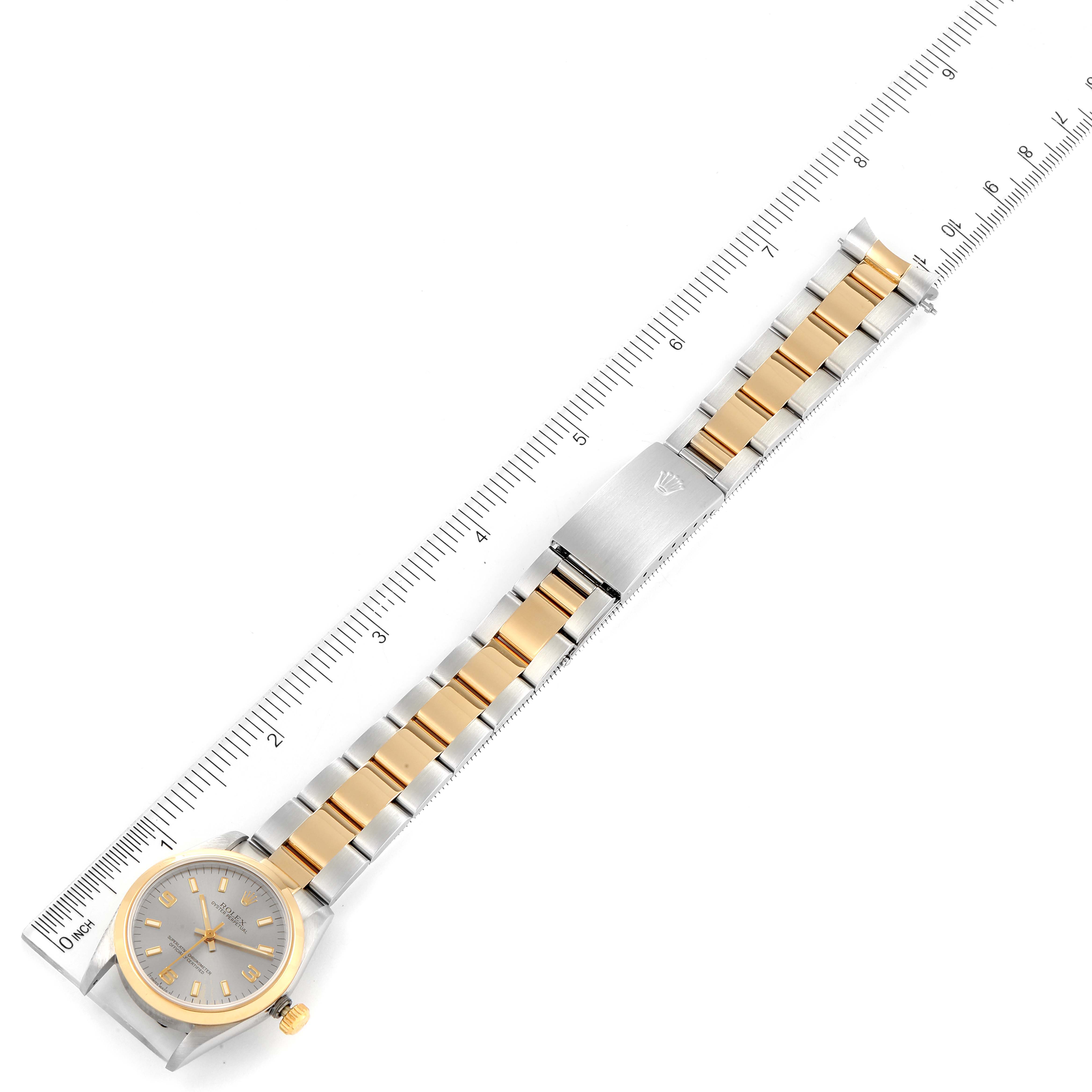 This image shows a top-down view of a Rolex Mid-Size 67483 Women
s Steel and Gold (two tone) Grey Dial 67483 Women
s Steel and Gold (two tone) Grey Dial watch, including the face, bezel, and two-tone bracelet, alongside a ruler for scale.