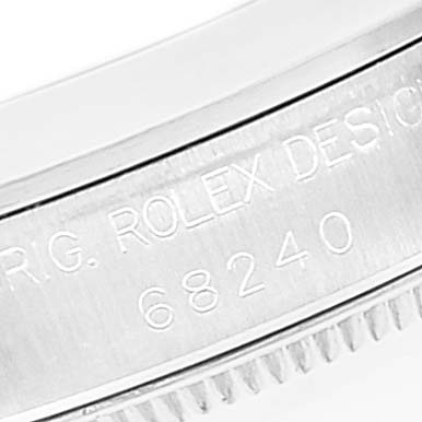 The image shows a close-up of the engraved bezel of a Mid-Size Rolex watch, highlighting the model number and brand details.