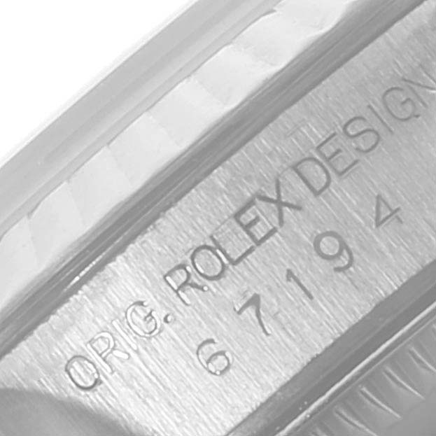 This is a close-up view of the engraved case side of a Rolex Oyster Perpetual 67194 Women's Stainless Steel Black Dial 67194 Women's Stainless Steel Black Dial watch showing its design number and branding.