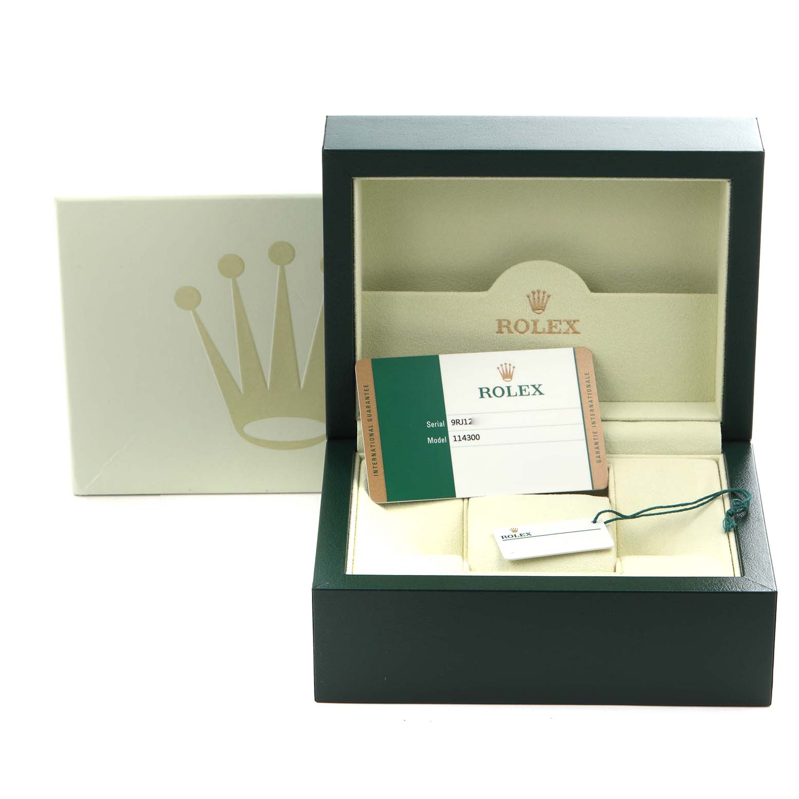 The image shows a Rolex Oyster Perpetual 114300 Men's Stainless Steel Grey Dial 114300 Men's Stainless Steel Grey Dial box with an open lid, warranty card, and tag inside.