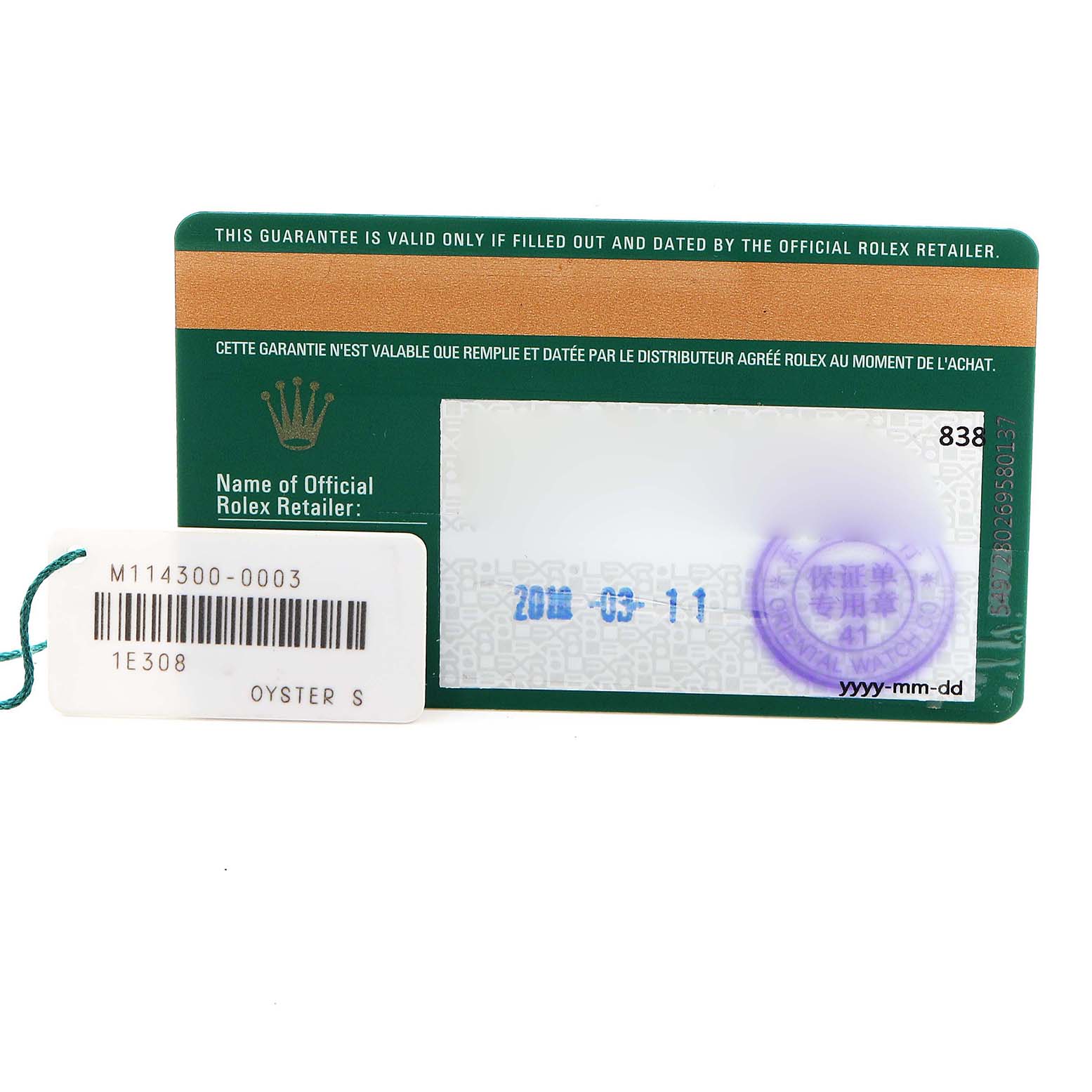 The image shows the warranty card and tag for a Rolex Oyster Perpetual 114300 Men's Stainless Steel Blue Dial 114300 Men's Stainless Steel Blue Dial, displayed from above.