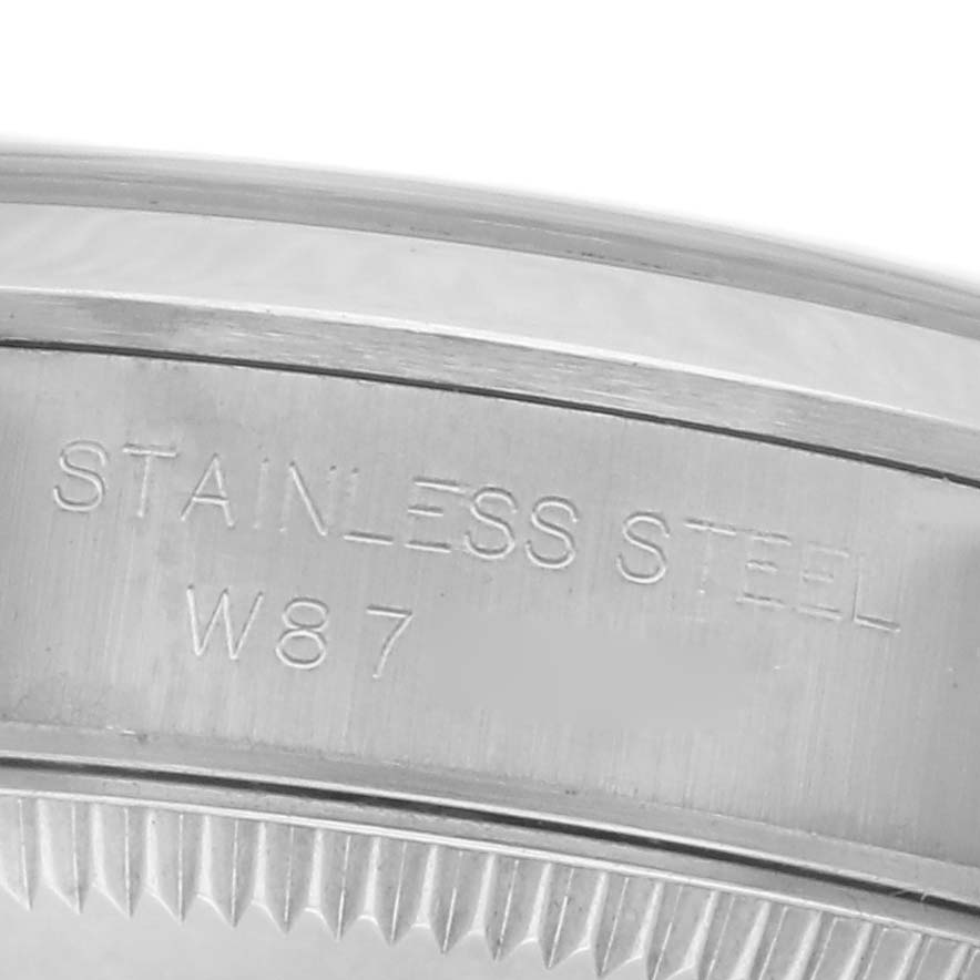 The image shows a close-up of the side engraving on the bezel of a Rolex Oyster Perpetual 67180 Women's Stainless Steel Pink Dial 67180 Women's Stainless Steel Pink Dial, highlighting "Stainless Steel W87."
