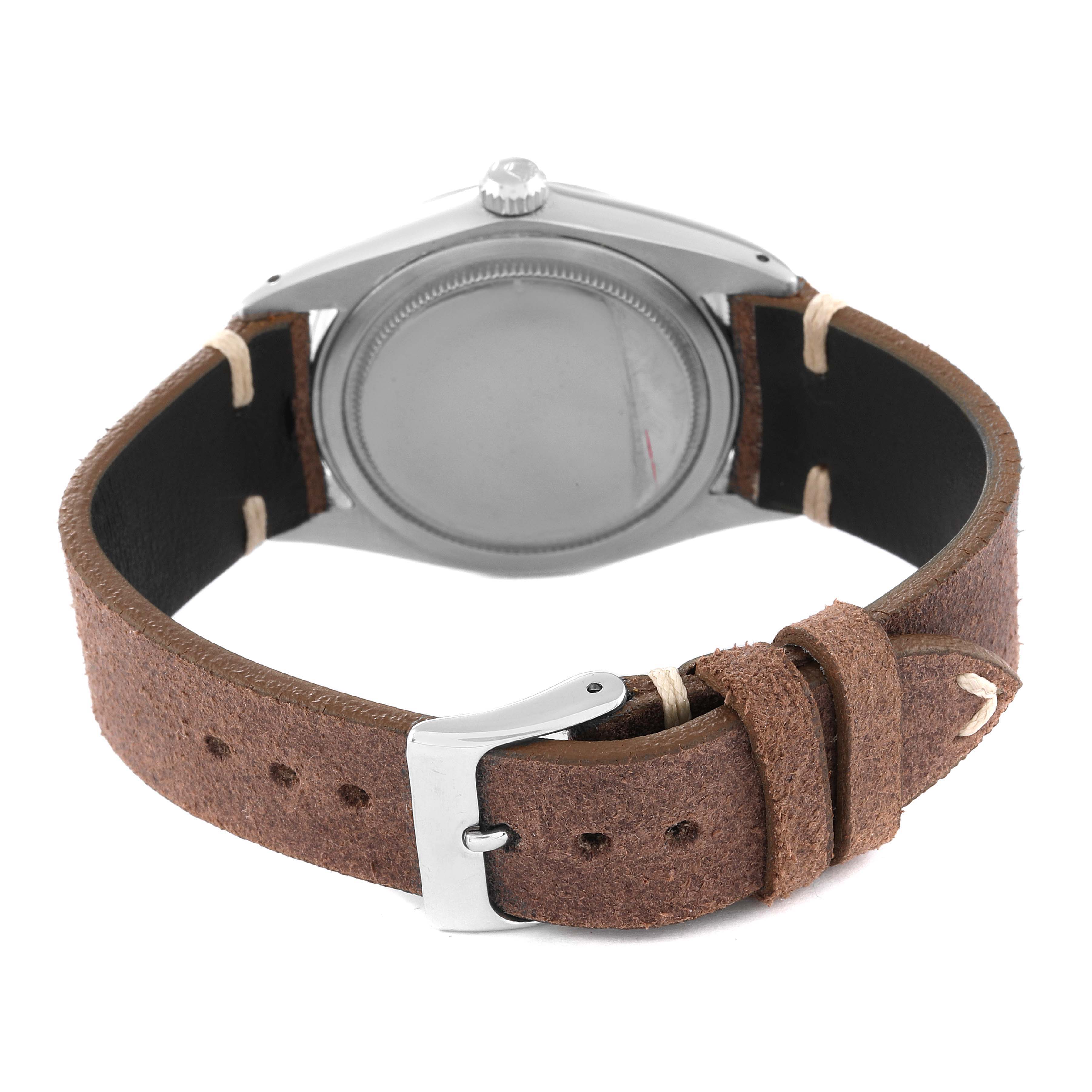The back view of the Vintage Collection Rolex watch showcases the case back and brown leather strap with a silver buckle.