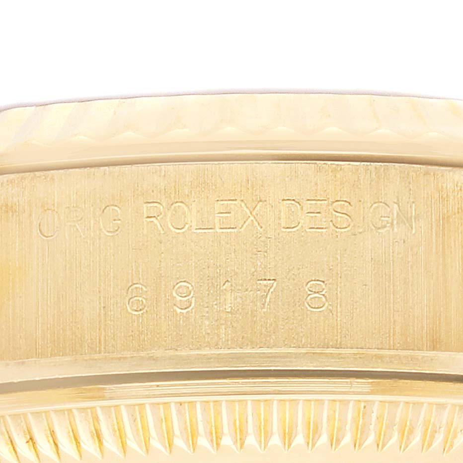 The image shows a close-up of the side engraving on a Rolex President 69178 Women
s Yellow Gold Champagne Dial 69178 Women
s Yellow Gold Champagne Dial model, revealing the model number and "ORIG ROLEX DESIGN."